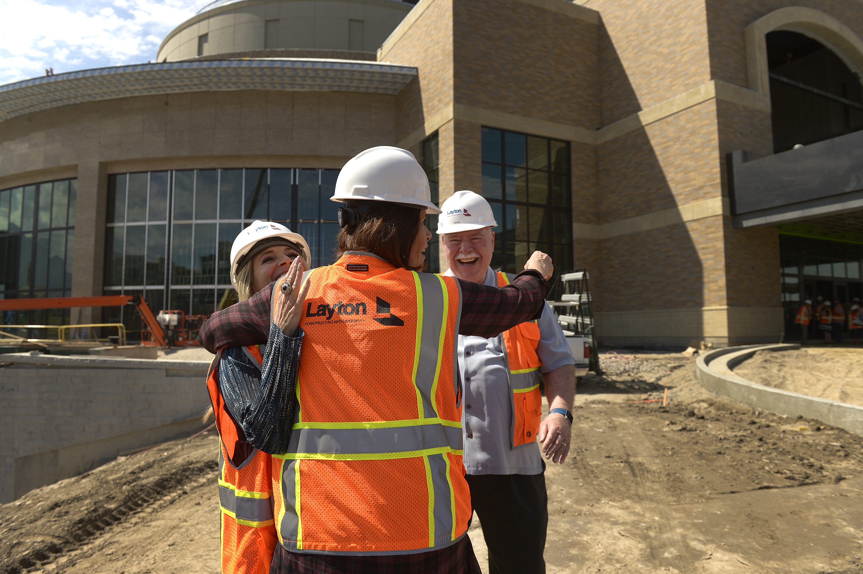 (Leah Hogsten | The Salt Lake Tribune) Sandy City communications director Nicole Martin, (left) and Sandy City Mayor Tom Dolan laugh as Hale Centre Theatre vice president Sally Dietlein hug them on the theatre's construction site. The Mountain American Performing Arts Centre is the new 130,000 square feet home to new Hale Centre Theatre, August 8, 2017.