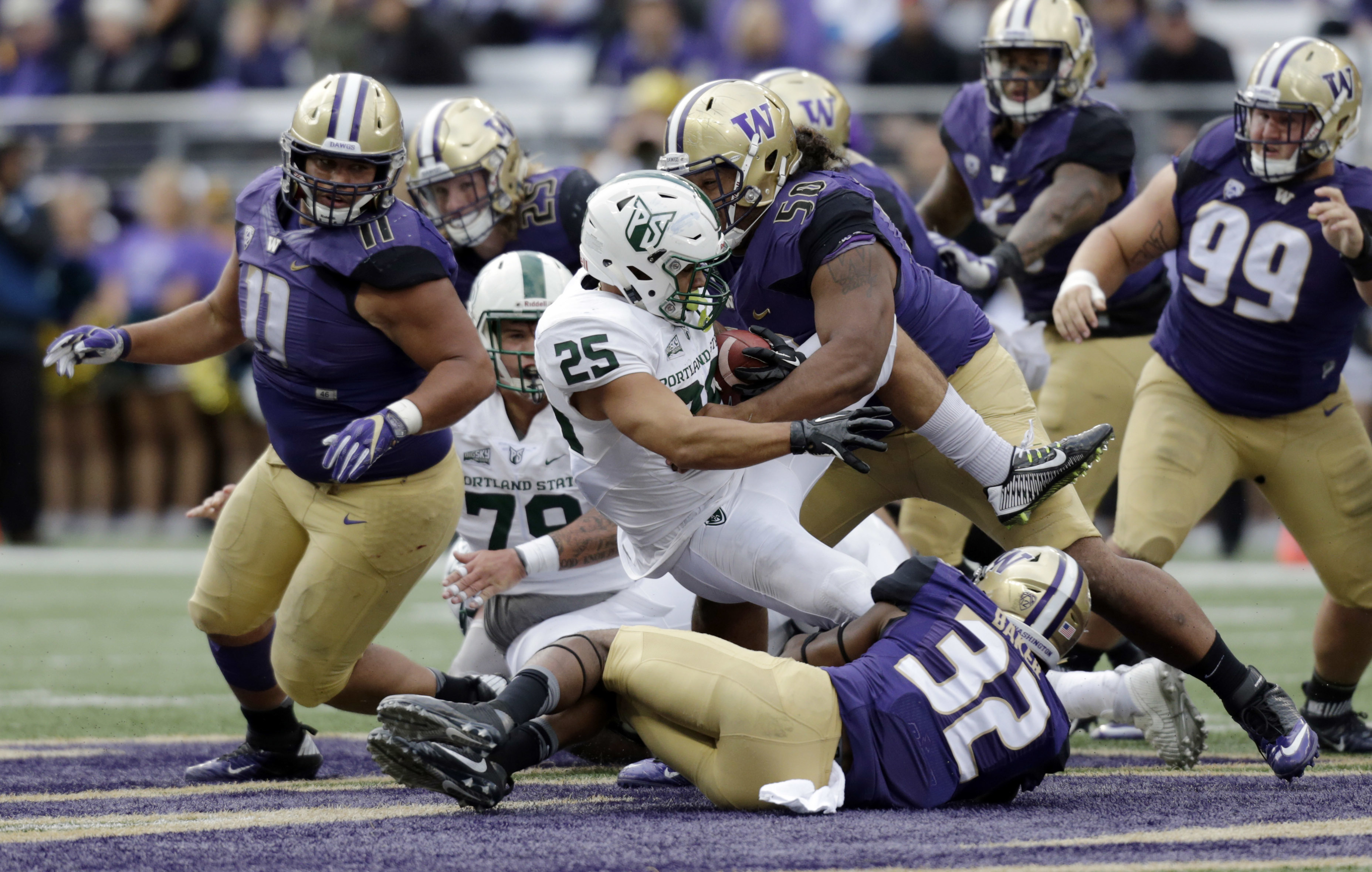 Portland State running back Nate Tago is tackled by Washington defensive back Budda Baker (32) and defensive lineman Vita Vea (50) with defensive lineman Elijah Qualls (11) closing in an NCAA college football game, Saturday, Sept. 17, 2016, in Seattle. (AP Photo/John Froschauer)