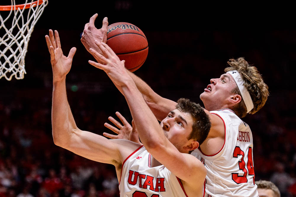 (Trent Nelson | The Salt Lake Tribune) Utah Utes forward Riley Battin (21) and Utah Utes center Jayce Johnson (34) reach for a rebound as Utah hosts Oregon State, NCAA basketball in Salt Lake City on Saturday Feb. 2, 2019.