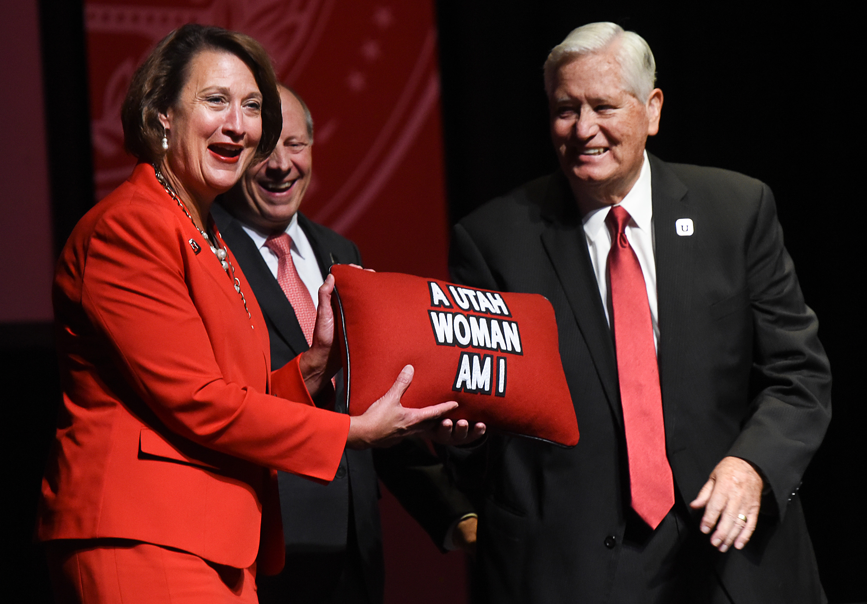 (Francisco Kjolseth | The Salt Lake Tribune) Ruth Watkins laughs as she is given a pillow printed with “A Utah Woman Am I” — a reference to the school's "Utah Man" fight song — at her Friday inauguration as the University of Utah’s 19th president. Watkins made history by being the first woman to hold the position. Five of Utah’s colleges are now led by women. Watkins was presented the pillow by Harris H. Simmons, with the board of regents, center, and H. David Burton with the board of trustees during her inauguration at Kingsbury Hall on Friday, Sept. 21, 2018.