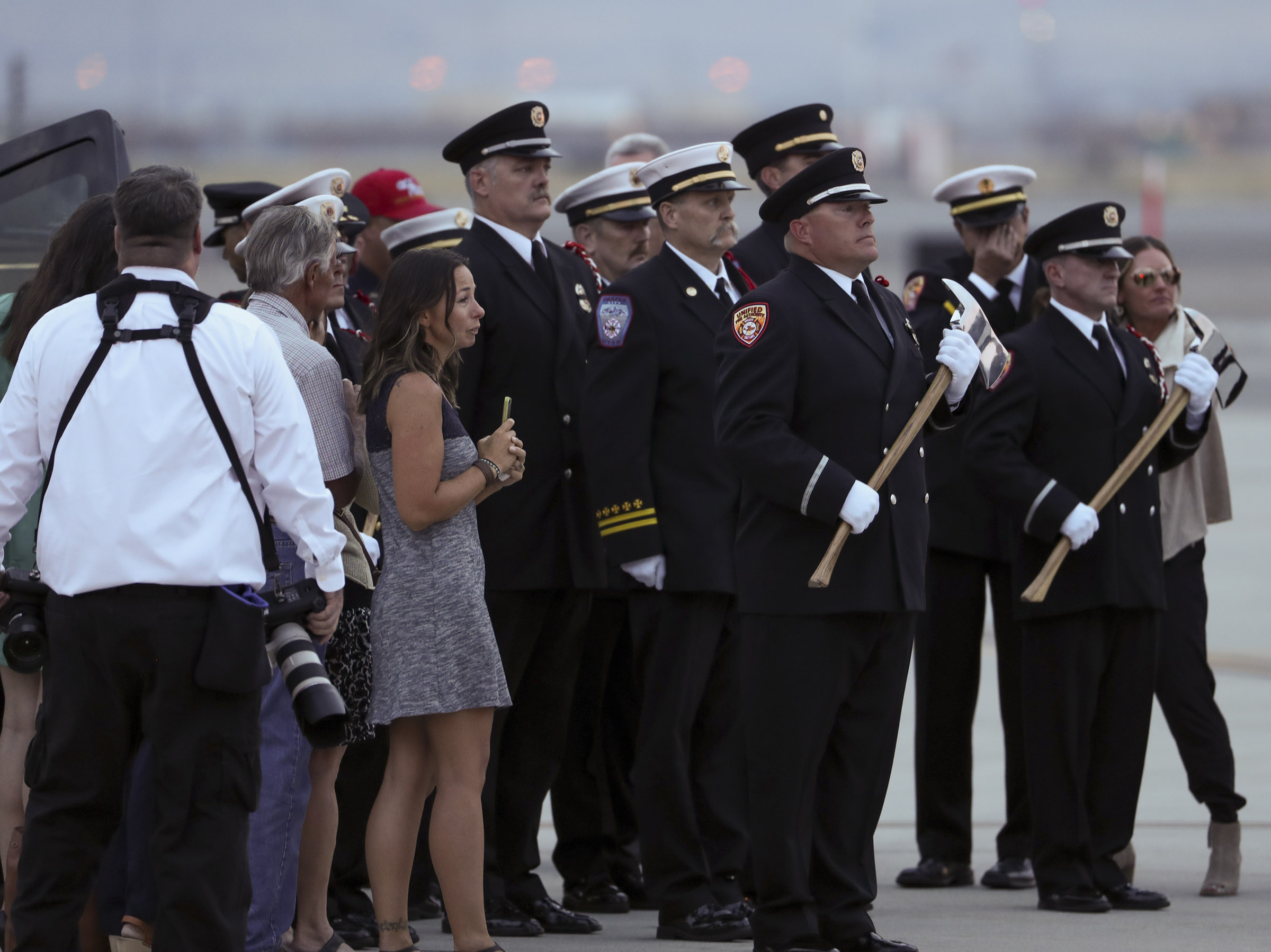 (Steve Griffin | Deseret News, pool photo) Members of the Draper City Fire Department and Unified Fire Authority Honor Guard stand with family members after the casket of Draper Battalion Chief Matt Burchett is placed in a hearse after being transported from California to Utah in a C130-J by the California Air National Guard. The C130-J landed at the Utah Air National Guard Base in Salt Lake City on Wednesday, Aug. 15, 2018. Burchett was killed while fighting the Mendocino Complex Fire north of San Francisco.