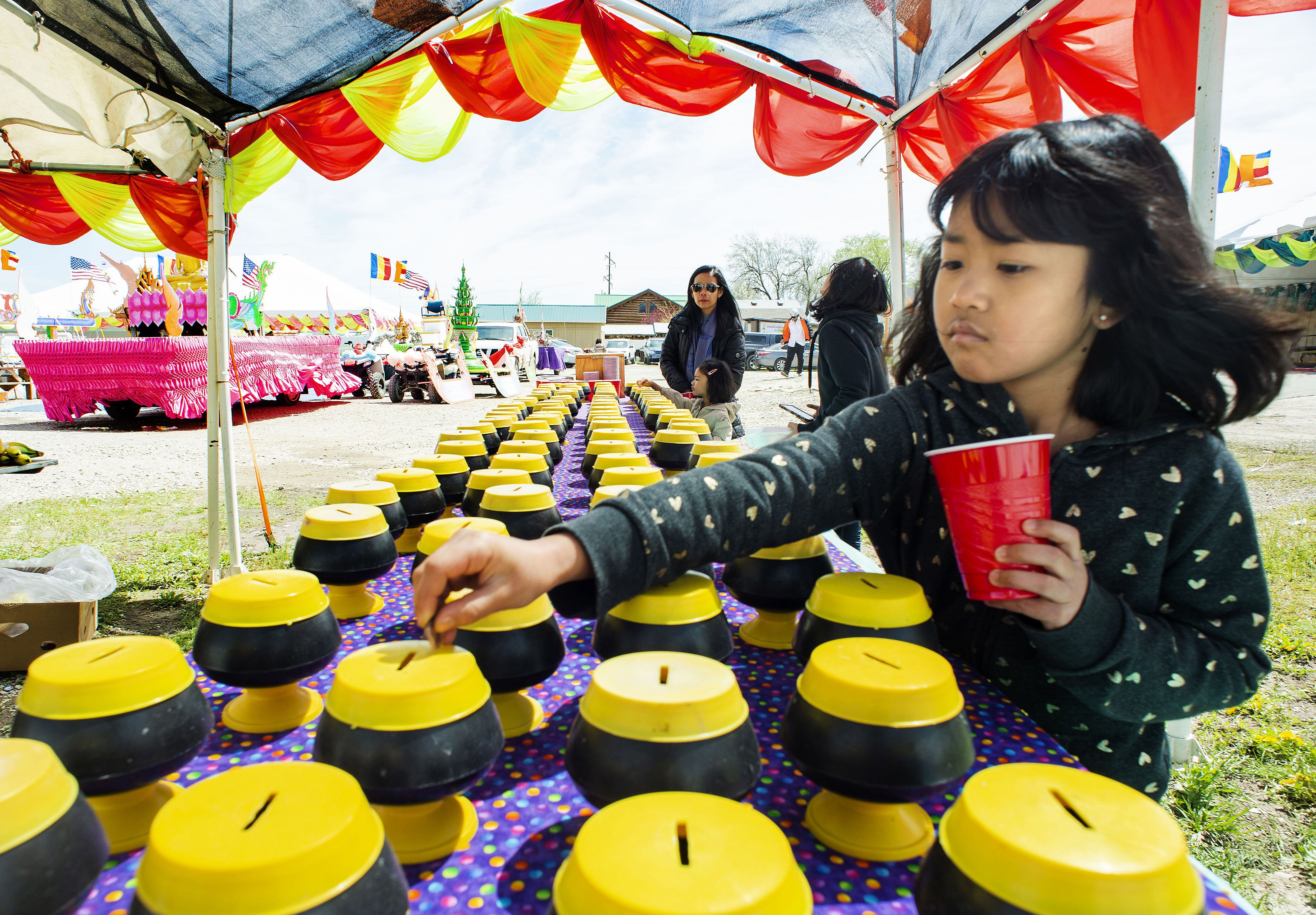 (Rick Egan | The Salt Lake Tribune) Jawmarana Trai 8, puts money in the bank for the monks, during the Wat Lao Salt Lake Buddharam Utah, New Year Celebration, in West Valley City, Sunday, April 28, 2019. 