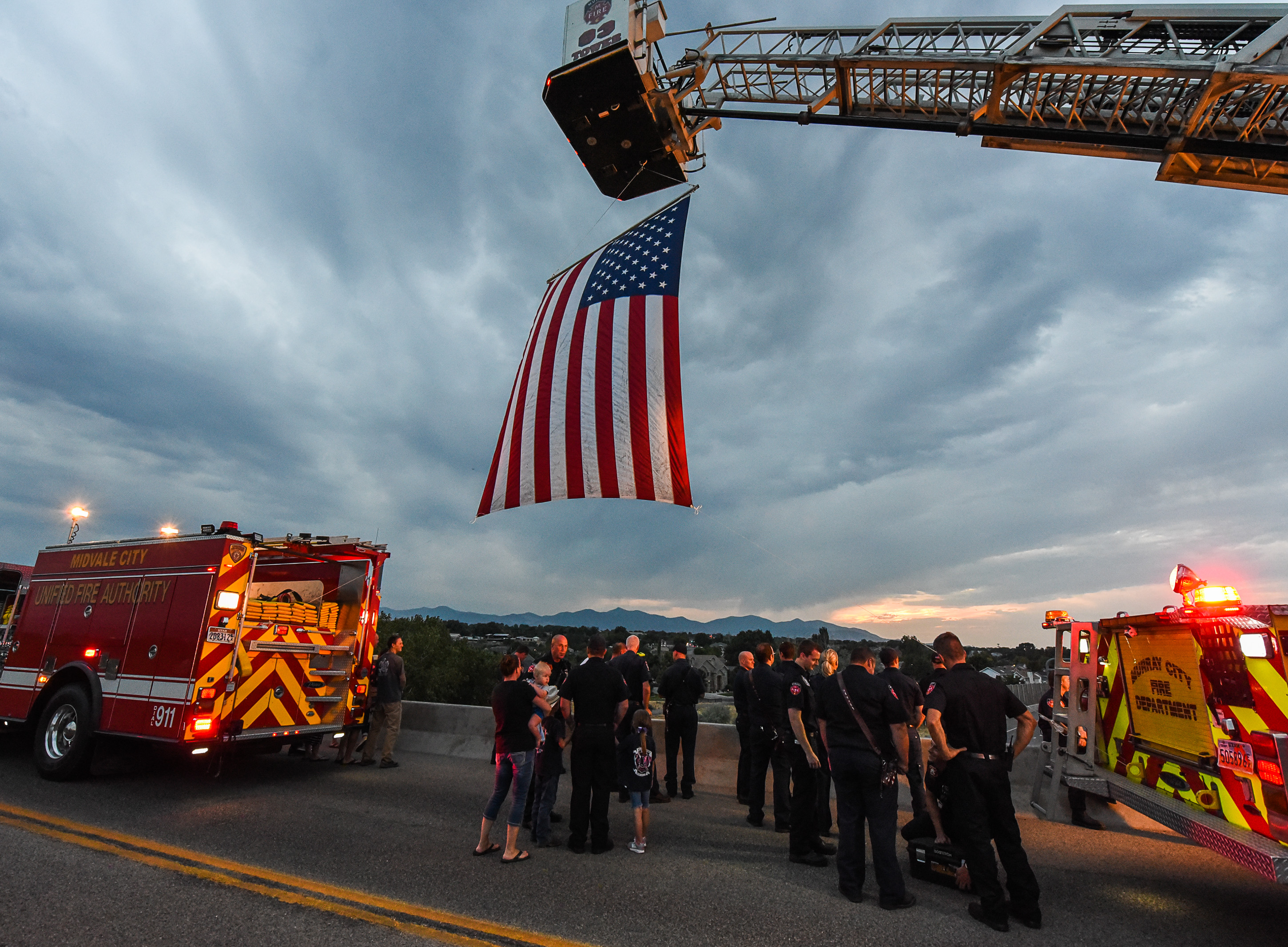 (Francisco Kjolseth | The Salt Lake Tribune) The body of Utah firefighter Matt Burchett, 42, who died fighting a wildfire in California is honored by a firefighter detail along Murray Parkway as his body is returned home, traveling along I-215 after being flown in to the Utah Air National Guard in Salt Lake City on Wed. Aug. 15, 2018. The remains of the Draper battalion chief were transported to Jenkins-Soffe Mortuary in South Jordan.