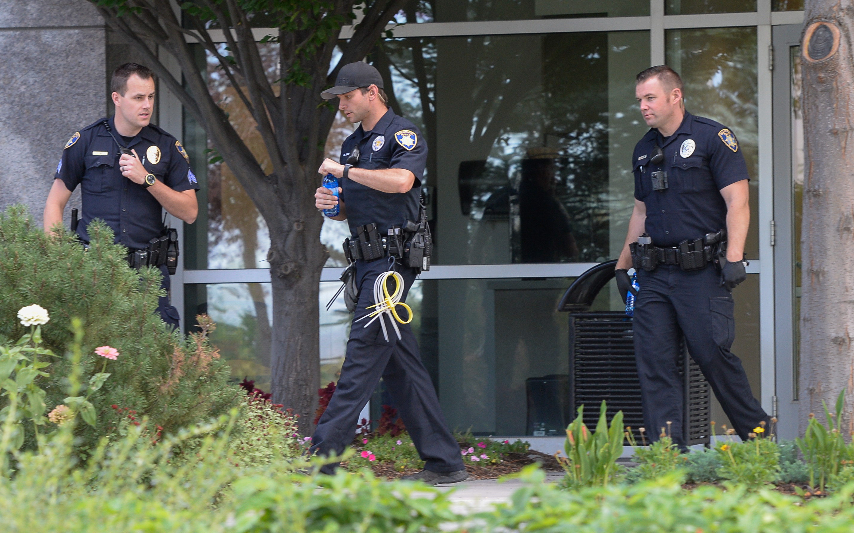 (Francisco Kjolseth | The Salt Lake Tribune) Law enforcement leaves the building where activists staged a protest against a private prison company with contracts to hold undocumented immigrants on Thursday, July 12, 2018, at the headquarters of Management and Training Corporation in Centerville.