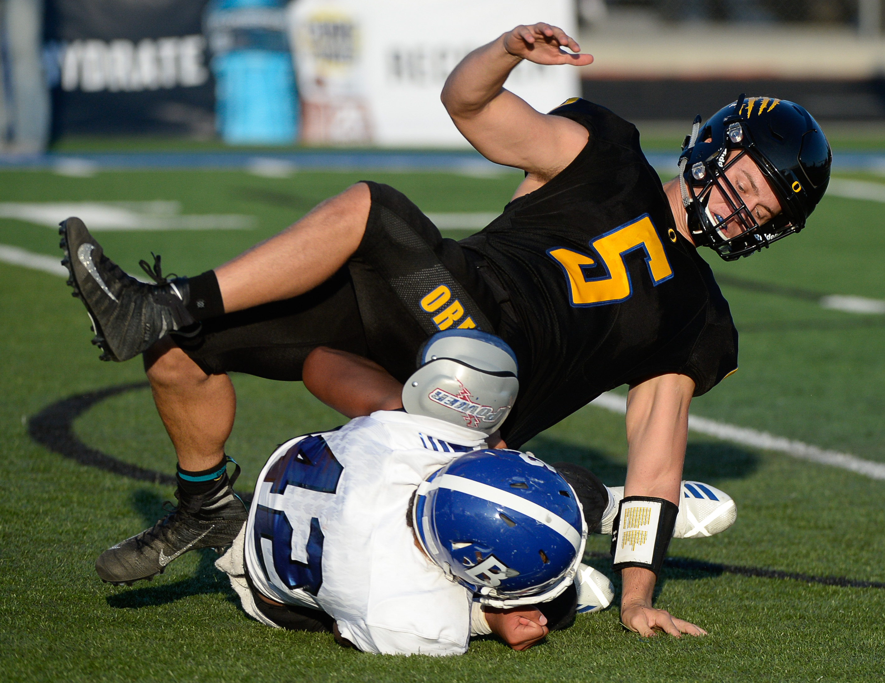(Francisco Kjolseth | The Salt Lake Tribune) Orem's quarterback Cooper Legas is taken down by Bingham's Sione Fotu in the first half of the game Thursday, Aug. 16, 2018 in Orem.