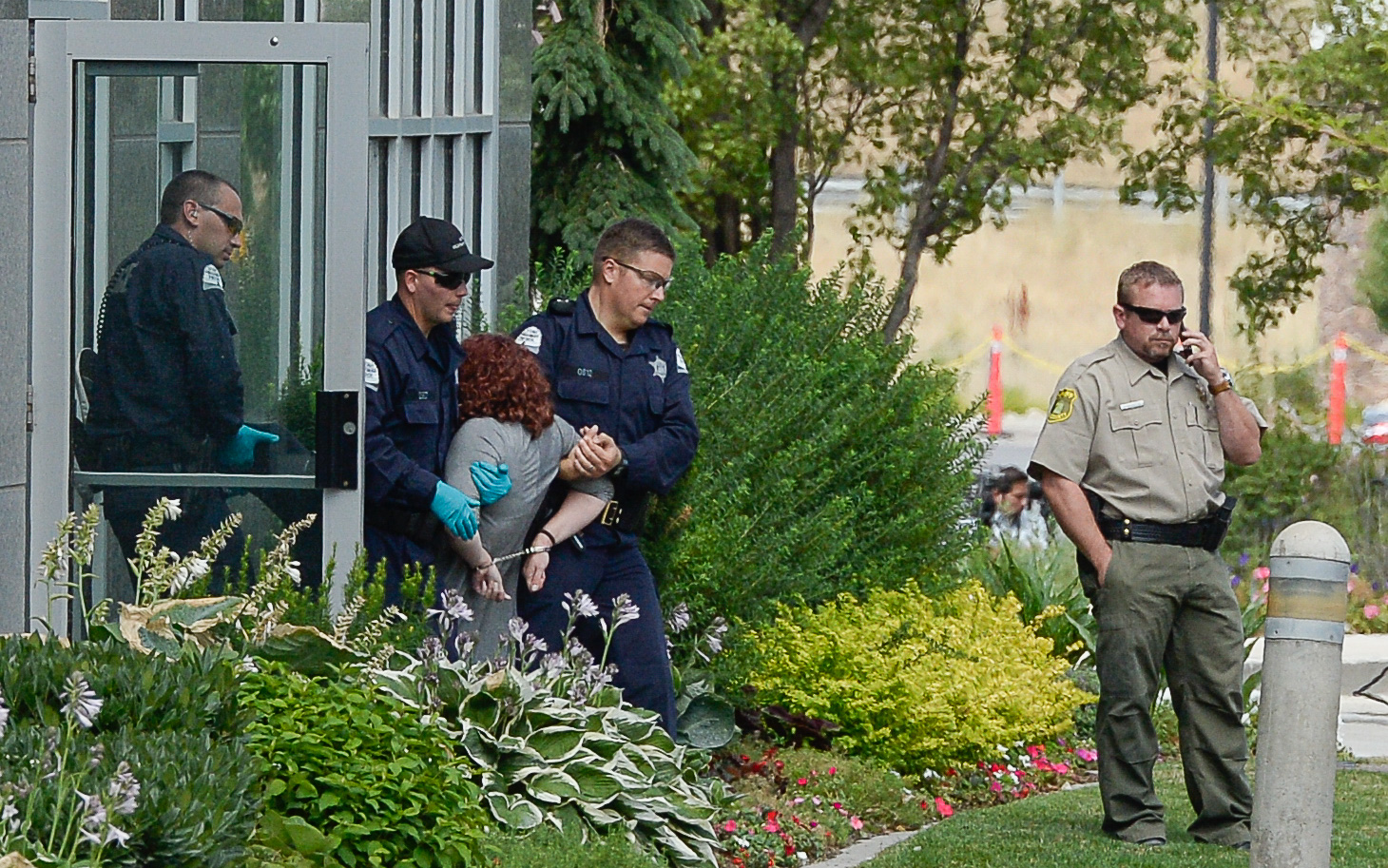 (Francisco Kjolseth | The Salt Lake Tribune) Activists are escorted out of a building where they staged a protest against a private prison company with contracts to hold undocumented immigrants on Thursday, July 12, 2018, at the headquarters of Management and Training Corporation in Centerville.