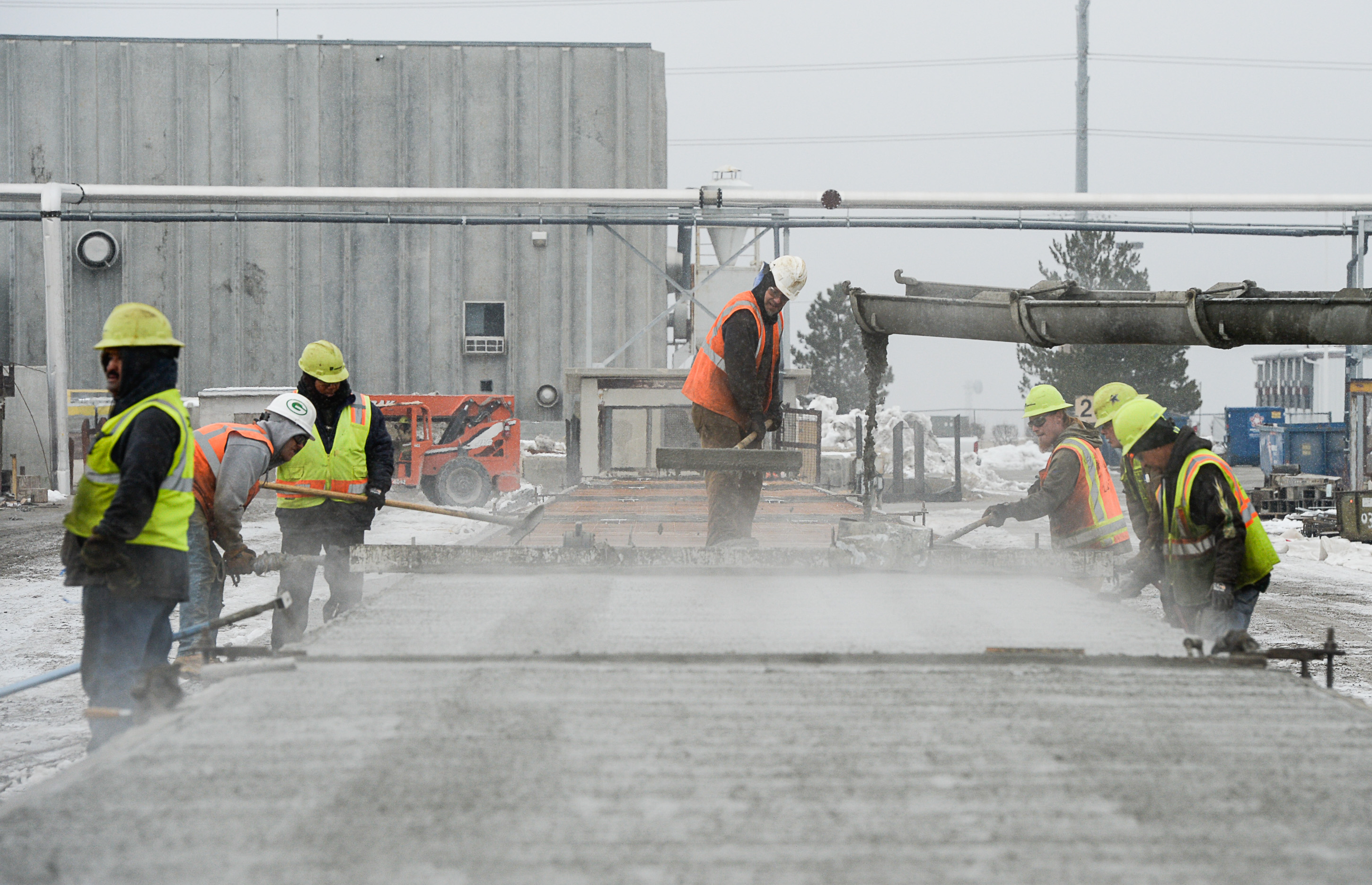 (Francisco Kjolseth | The Salt Lake Tribune) Crews lay down cement on a double T structure at Forterra Structural Precast as nearby UDOT gets ready to place some of the world's largest-ever bridge beams, and the largest in Utah state history with a span of 203 ft long and just over 8 ft tall, on to a truck following manufacturing in Kearns on Tuesday, Dec. 11, 2018. A total of six beams will be installed in the technology corridor in Lehi later this week.