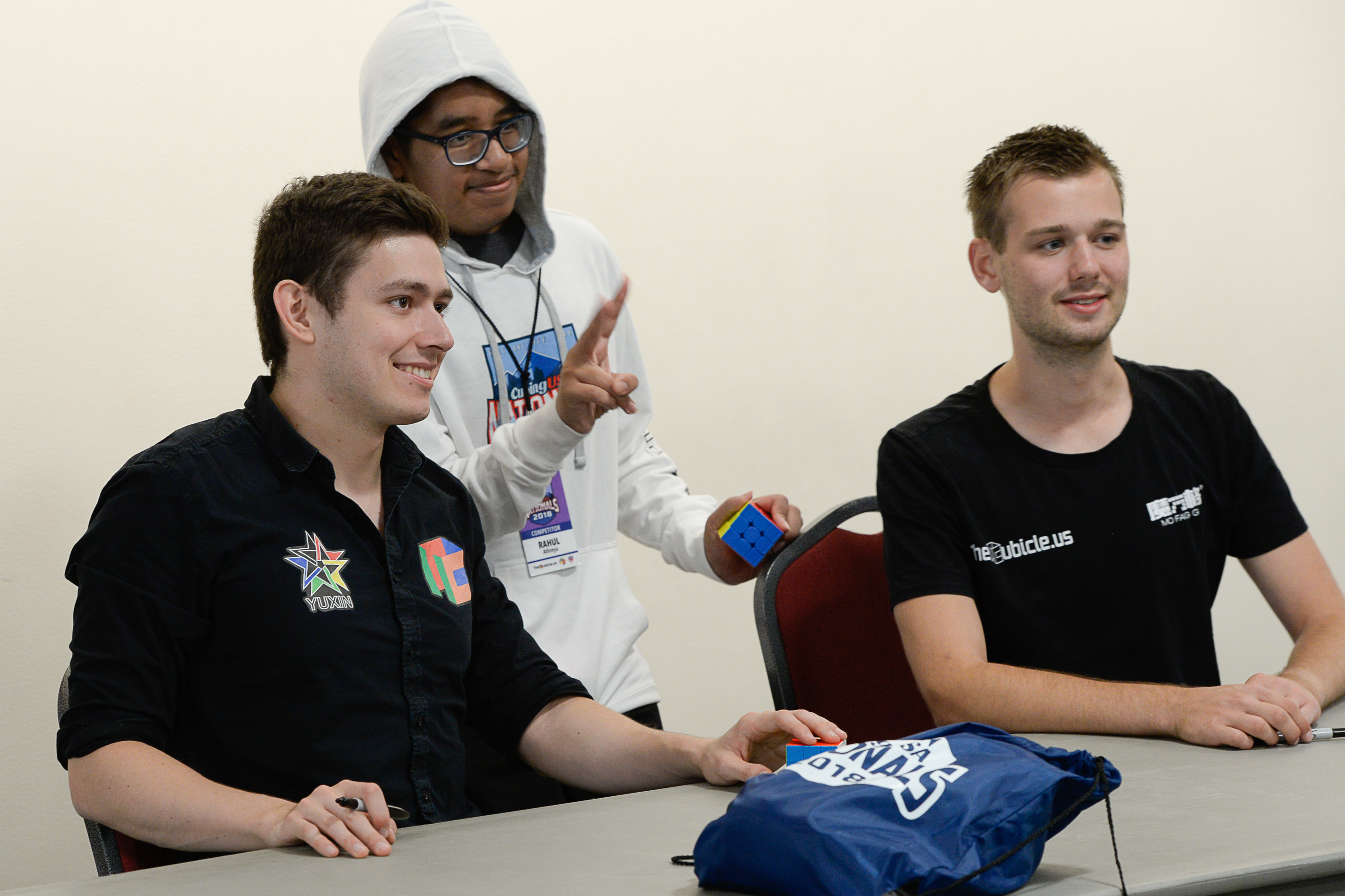 (Francisco Kjolseth | The Salt Lake Tribune) Rubik's Cube champions Kevin Hays, left, and Mats Valk pose for a photograph with Rahul Athreya of Phoenix during an autograph session at CubingUSA Nationals 2018 at the Salt Palace Convention Center in Salt Lake City on Saturday, July 28, 2018. Hays was the first person to win the 5x5, 6x6, and 7x7 events at one world championship.
