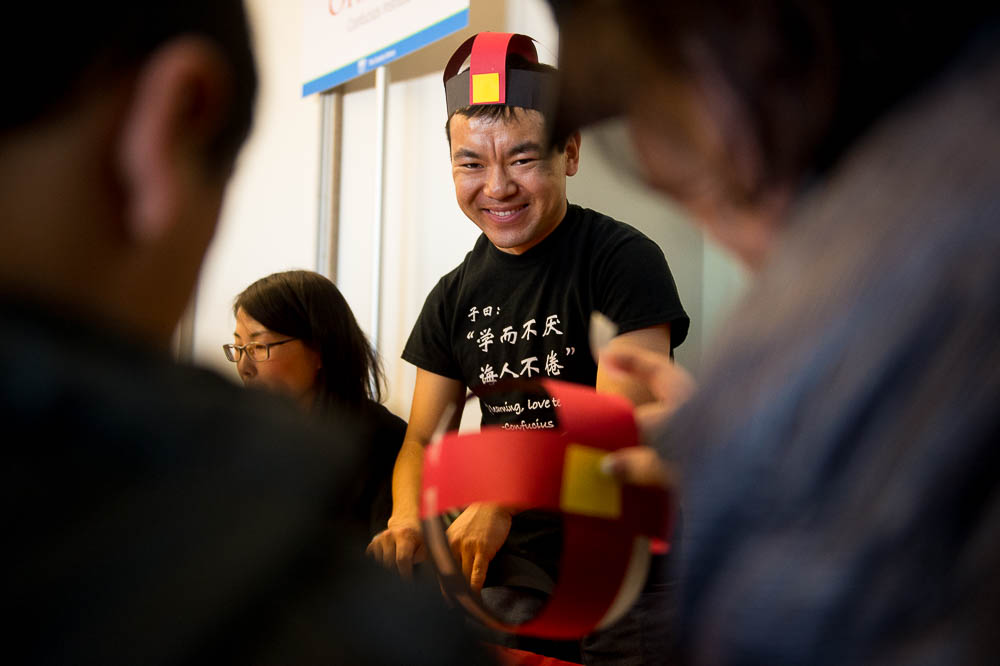 (Trent Nelson | The Salt Lake Tribune) Xi Qiang helps children construct Chinese hats at the Chinese New Year Celebration at the County Library's Viridian Event Center in West Jordan, Saturday Feb. 17, 2018.