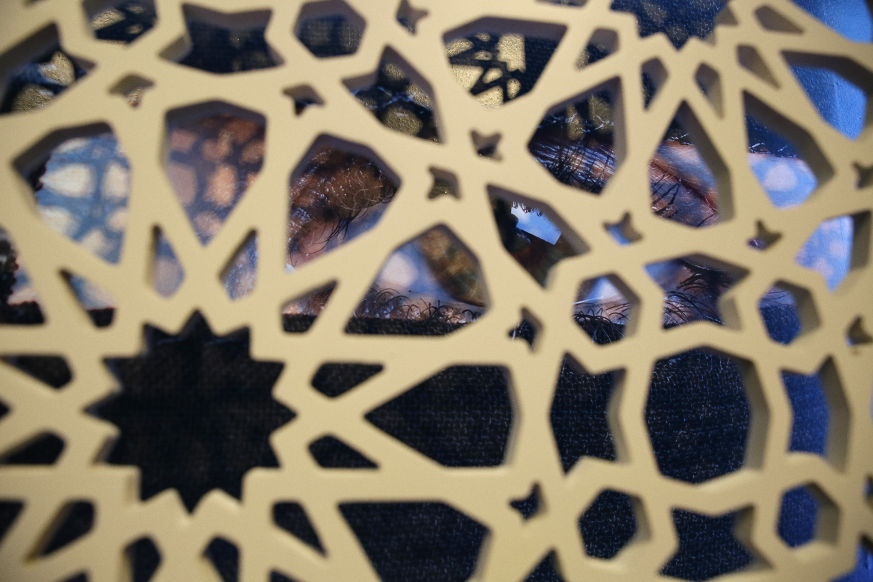 (Eric Risberg | AP Photo) In this photo taken Thursday, Sept. 20, 2018, a photograph of a woman's eye is seen behind a latticework in the exhibit Contemporary Muslim Fashions at the M. H. de Young Memorial Museum in San Francisco. The first major museum exhibition of contemporary Muslim women's fashion reflects designs from around the world that are vibrant and elegant, playful and diverse. The show's creators hope the exhibit will show Muslim women as real people who can choose what they wear rather than as subjects ordered to cover their entire bodies or restricted in what they can wear. The exhibit opens on Saturday.