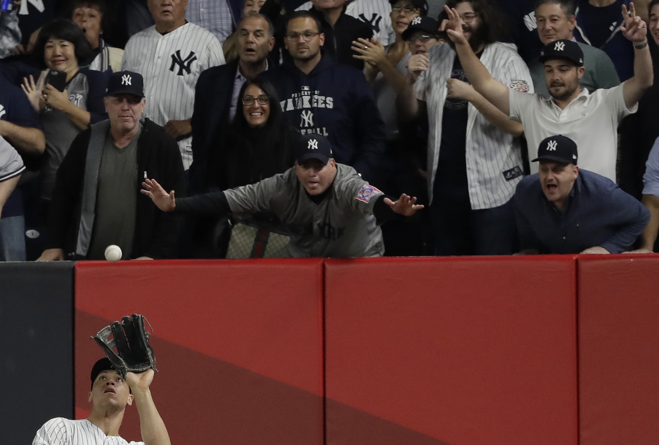 Fans watch as New York Yankees' Aaron Judge catches a long fly ball hit by Houston Astros' Alex Bregman during the seventh inning of Game 5 of baseball's American League Championship Series Wednesday, Oct. 18, 2017, in New York. (AP Photo/David J. Phillip)