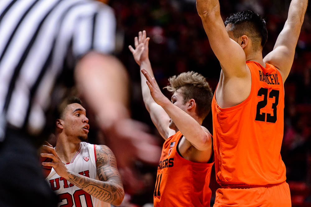 (Trent Nelson | The Salt Lake Tribune) Utah Utes forward Timmy Allen (20) looks to pass, defended by Oregon State Beavers guard Zach Reichle (11) and Oregon State Beavers center Gligorije Rakocevic (23) as Utah hosts Oregon State, NCAA basketball in Salt Lake City on Saturday Feb. 2, 2019.
