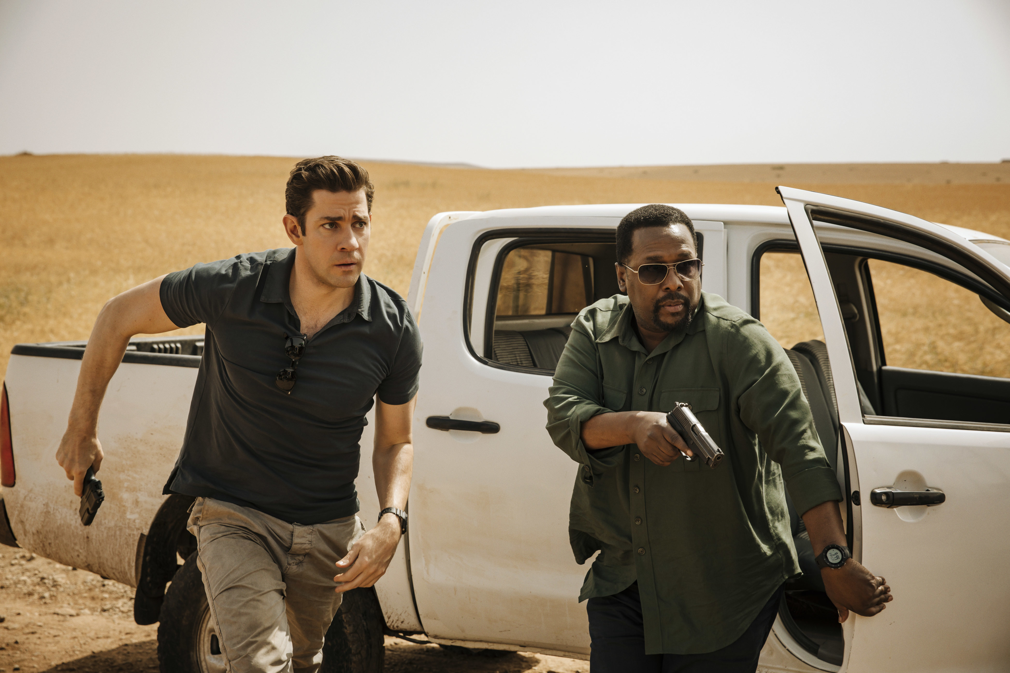 This image released by Amazon shows John Krasinski, left, and Wendell Pierce in a scene from "Tom Clancy's Jack Ryan." (Jan Thijs/Amazon via AP)