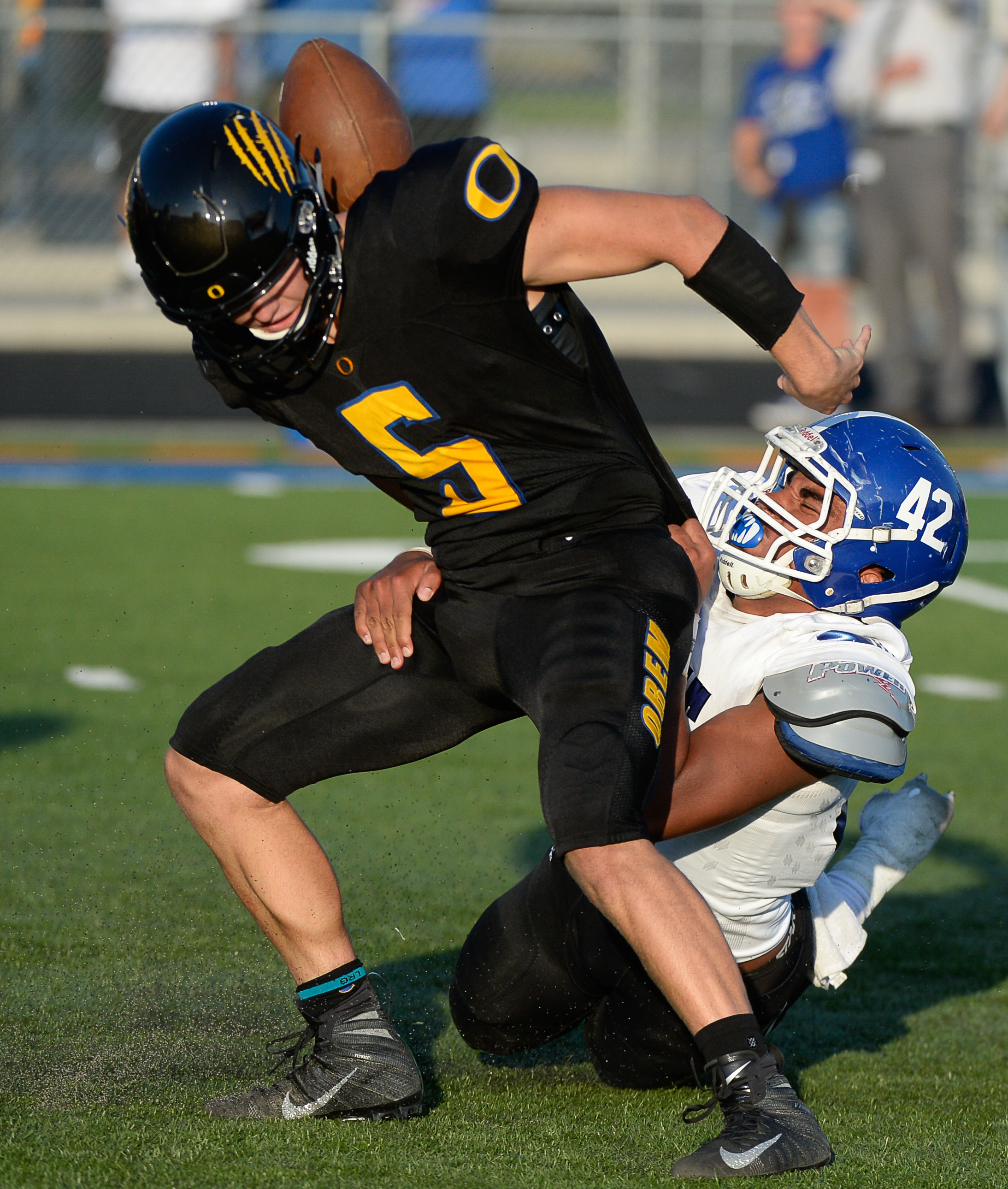 (Francisco Kjolseth | The Salt Lake Tribune) Orem's quarterback Cooper Legas is taken down by Bingham's Sione Fotu in the first half of the game Thursday, Aug. 16, 2018 in Orem.