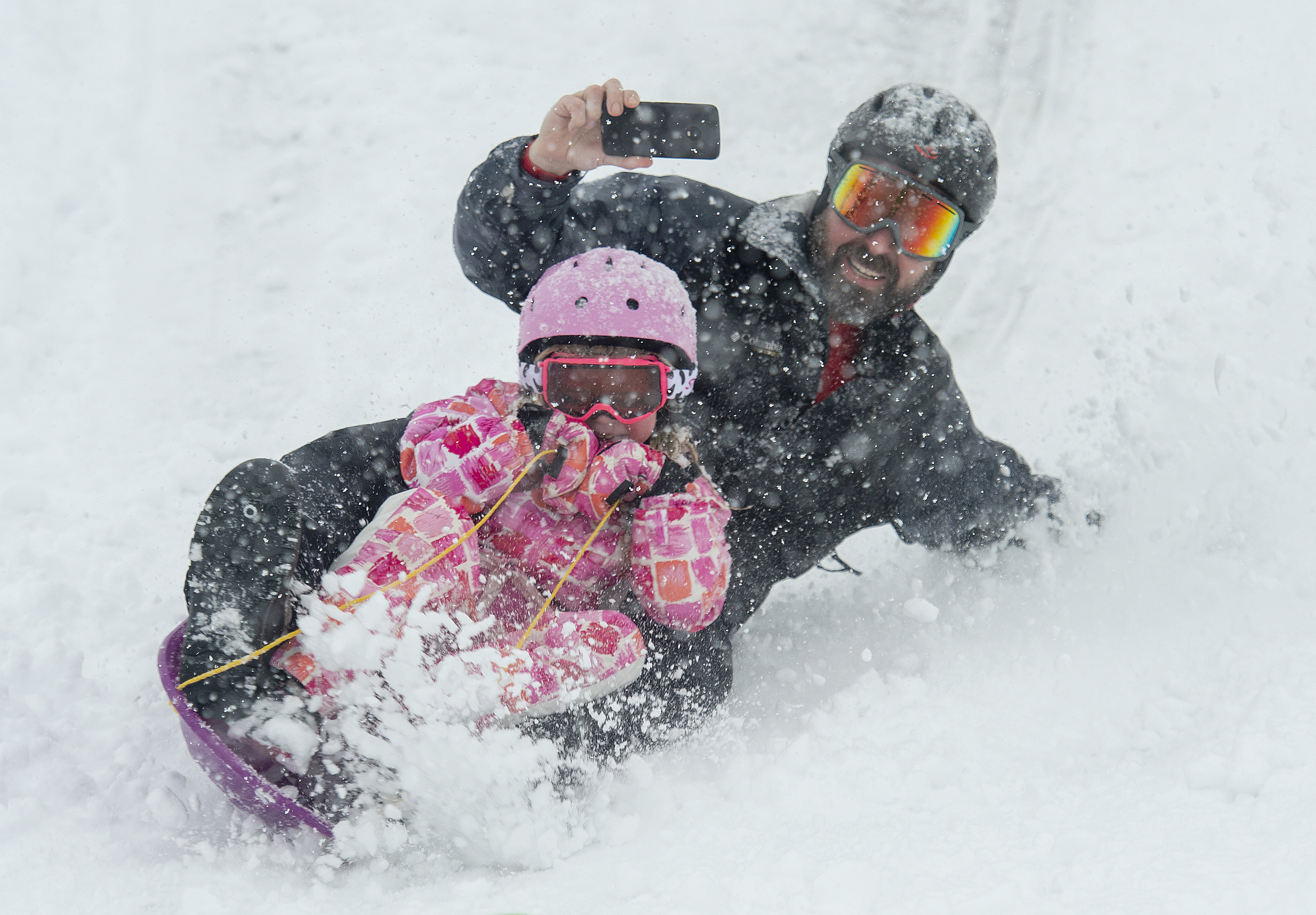 (Rick Egan | The Salt Lake Tribune) Mark Fehlberg, sleds down the hill with his daughter Amelia 7, at Popperton Park, Monday, Jan. 21, 2019. 