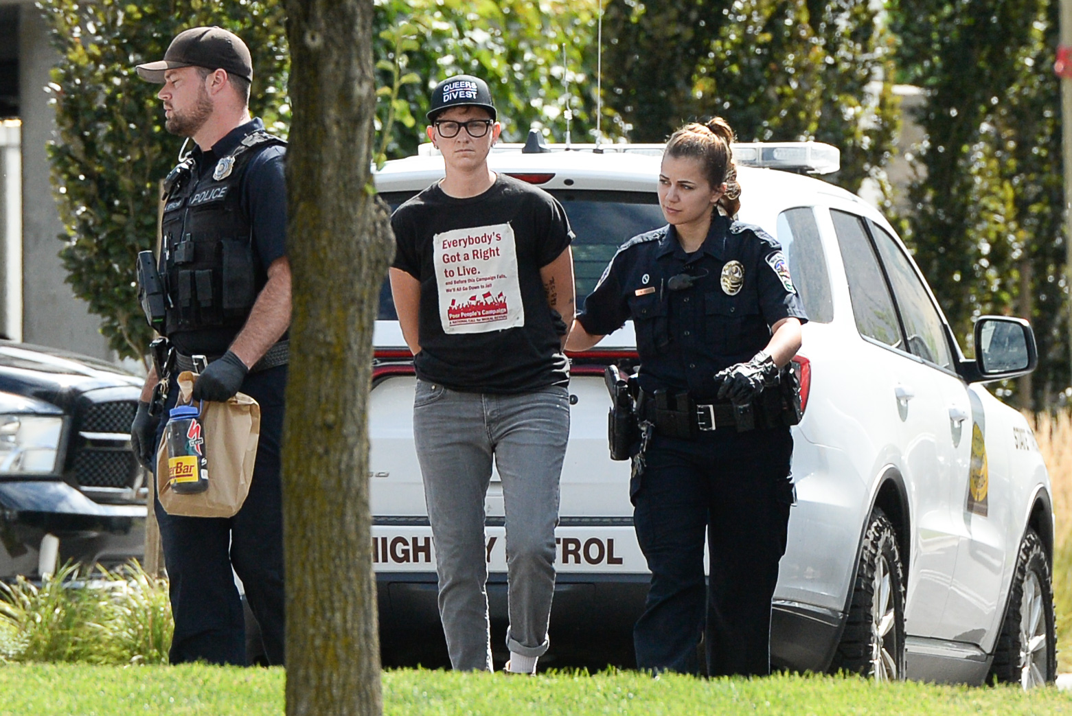 (Francisco Kjolseth | The Salt Lake Tribune) Activist Lesley Ann Shaw is escorted out of a building where they staged a protest against a private prison company with contracts to hold undocumented immigrants on Thursday, July 12, 2018, at the headquarters of Management and Training Corporation in Centerville.