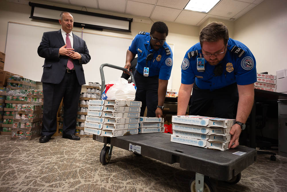 (Trent Nelson | The Salt Lake Tribune) Salt Lake City Mayor Jackie Biskupski had pizza delivered to TSA and other federal employees to thank them for working at the airport without pay during the partial federal shutdown on Tuesday Jan. 22, 2019. Food from the Utah Food Pantry was stacked around the training room to cover the needs of employees. From left are Mark Lewis, Marcus Smauldon, and Anthony Christensen.