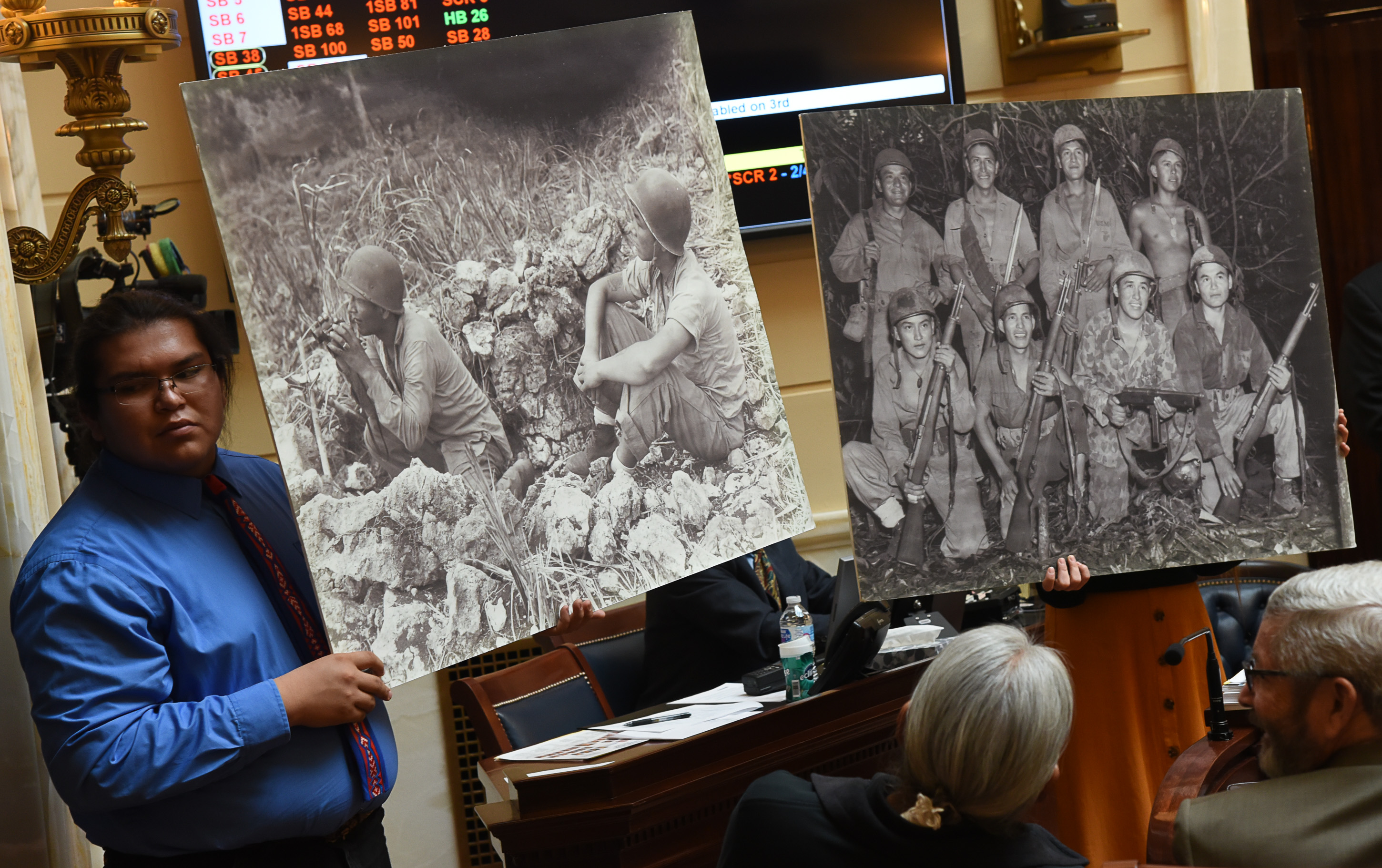 (Francisco Kjolseth | The Salt Lake Tribune) Gregory Hurley helps hold historic photographs on the Senate floor of Navajo Code Talkers being recognized at the Utah Capitol on Monday, Feb. 4, 2019.