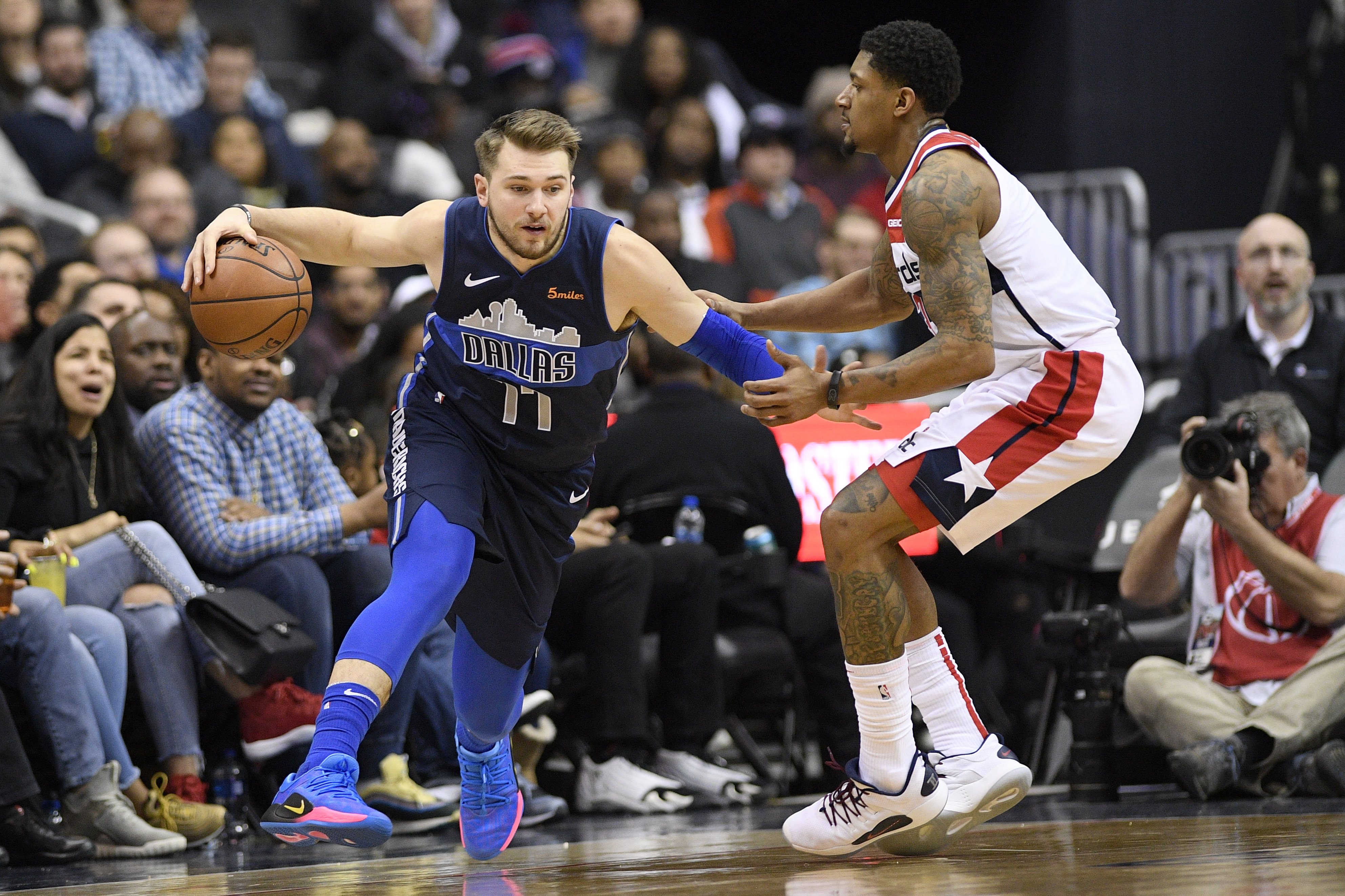 Dallas Mavericks forward Luka Doncic (77) dribbles the ball next to Washington Wizards guard Bradley Beal during the second half of an NBA basketball game Wednesday, March 6, 2019, in Washington. The Wizards won 132-123. (AP Photo/Nick Wass)