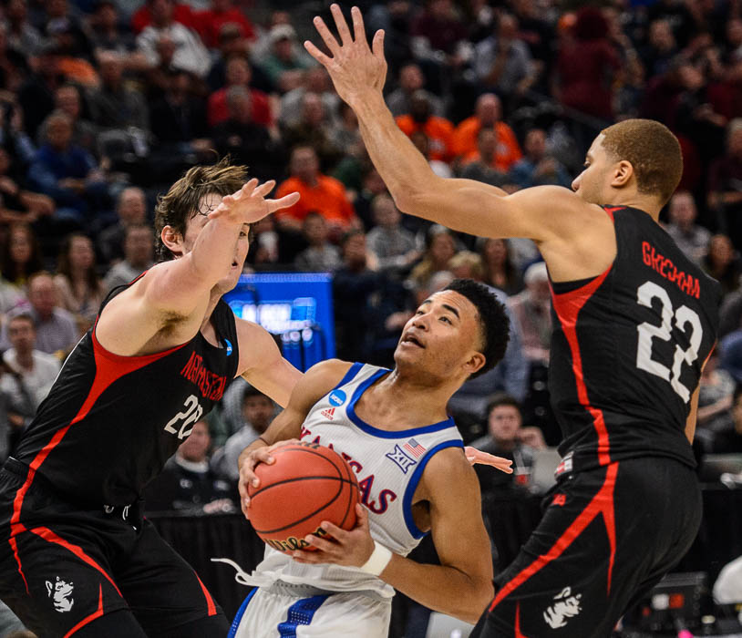 (Trent Nelson | The Salt Lake Tribune) Kansas Jayhawks guard Devon Dotson (11) drives on Northeastern Huskies guard Bolden Brace (20) and Northeastern Huskies guard Donnell Gresham Jr. (22) as Kansas faces Northeastern in the 2019 NCAA Tournament in Salt Lake City on Thursday March 21, 2019.