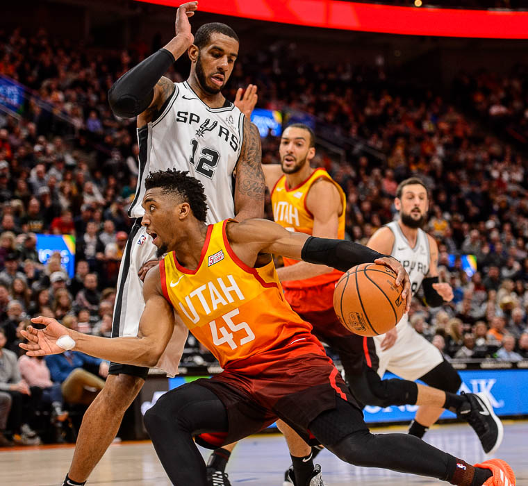 (Trent Nelson | The Salt Lake Tribune) Utah Jazz guard Donovan Mitchell (45) drives around San Antonio Spurs center LaMarcus Aldridge (12) as the Utah Jazz host the San Antonio Spurs, NBA basketball in Salt Lake City on Saturday Feb. 9, 2019.