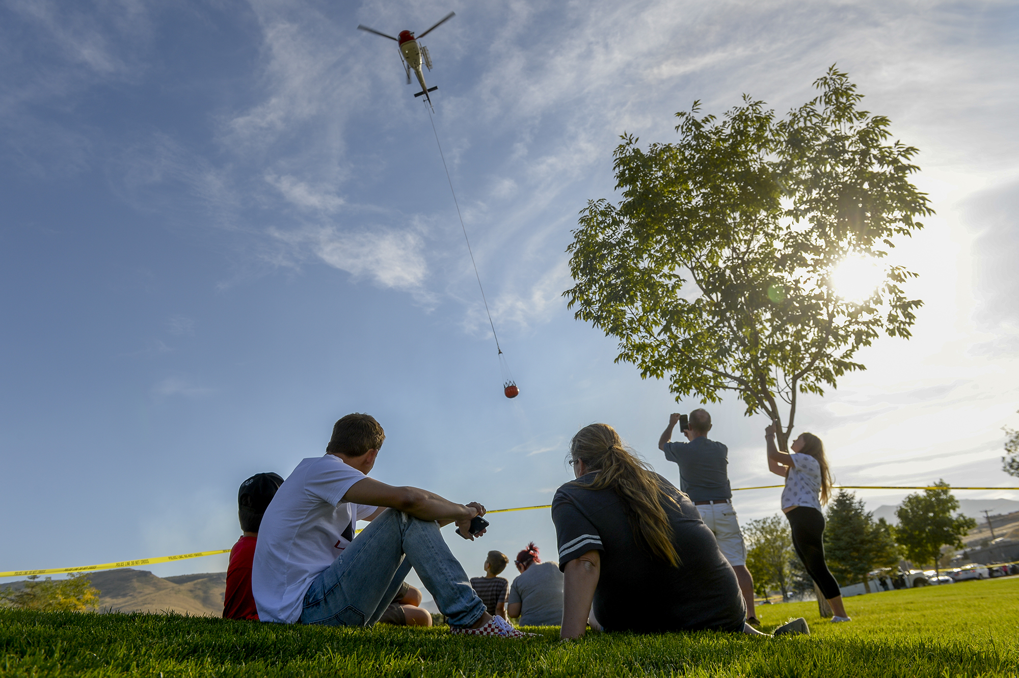 Leah Hogsten | The Salt Lake Tribune Homeowners who were not allowed to return to their homes and onlookers waited near Herriman Cove pond to watch as a firefighting helicopter refilled. A 50-acre wildfire in Rose Canyon was threatened about a half-dozen homes Wednesday, Sept. 12, 2018. A spokesman for Unified Fire said the blaze has already burned a few structures, including outhouses and sheds. Firefighters have evacuated around 20 to 30 homes in two neighborhoods near 15555 S. Rose Canyon Road in Herriman. 