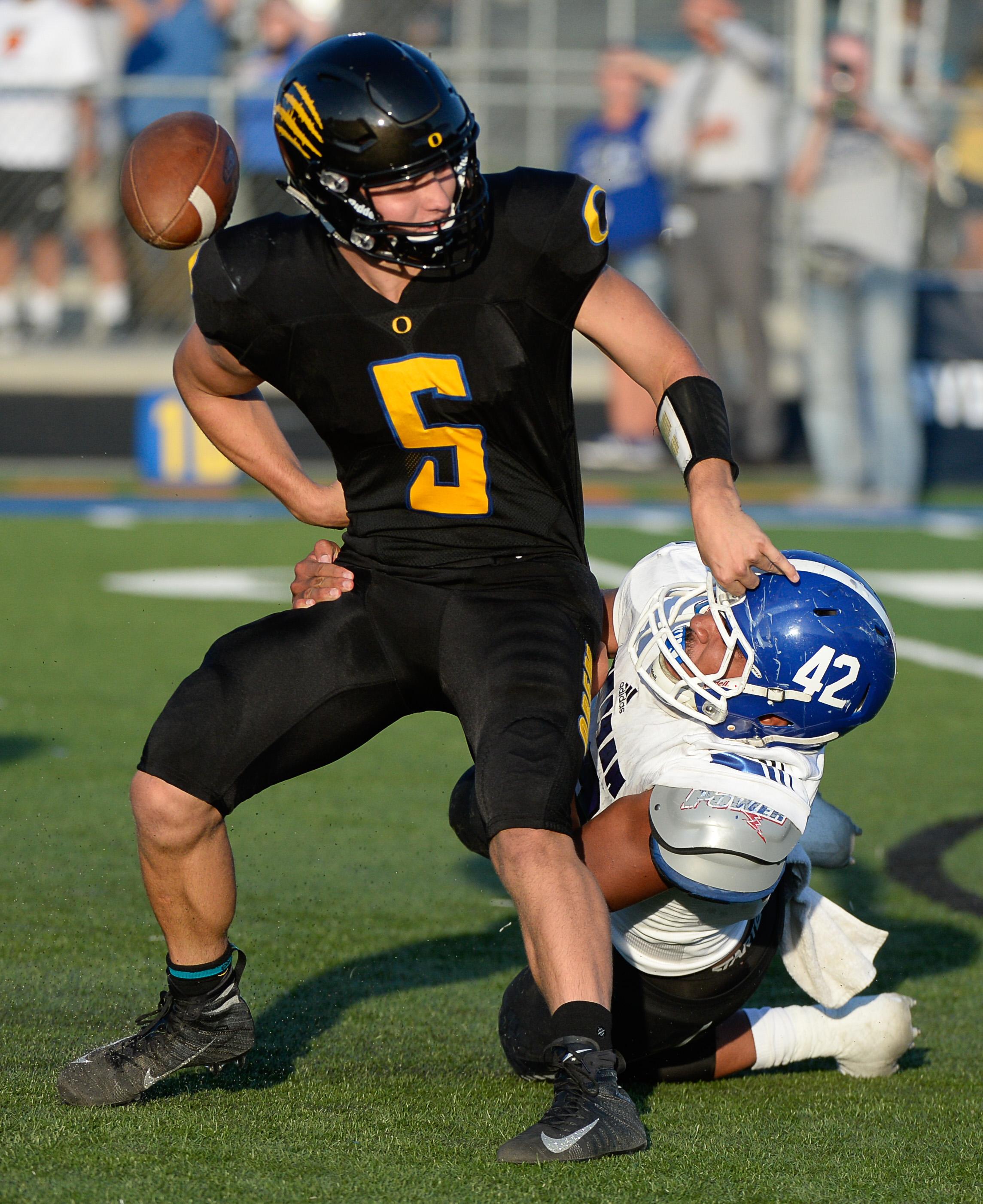 (Francisco Kjolseth | The Salt Lake Tribune) Orem's quarterback Cooper Legas is taken down by Bingham's Sione Fotu in the first half of the game Thursday, Aug. 16, 2018 in Orem.