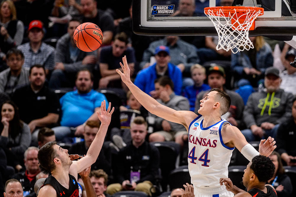 (Trent Nelson | The Salt Lake Tribune) Kansas Jayhawks forward Mitch Lightfoot (44) blocks a shot by Northeastern Huskies guard Vasa Pusica (4) as Kansas faces Northeastern in the 2019 NCAA Tournament in Salt Lake City on Thursday March 21, 2019.