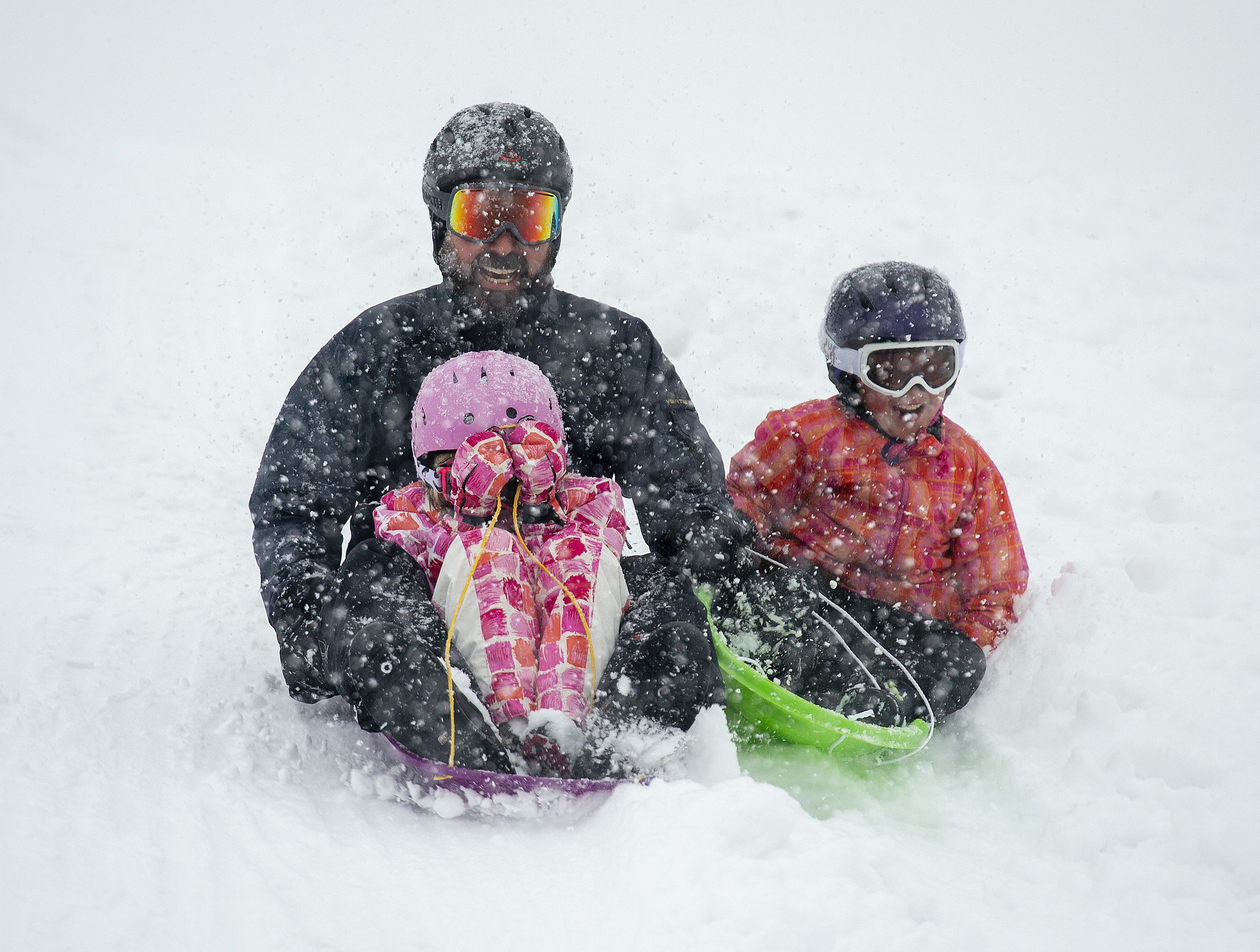 (Rick Egan | The Salt Lake Tribune) Mark Fehlberg, sleds down the hill with his daughter Amelia 7, and son Desmond, 7 at Popperton Park, Monday, Jan. 21, 2019. 