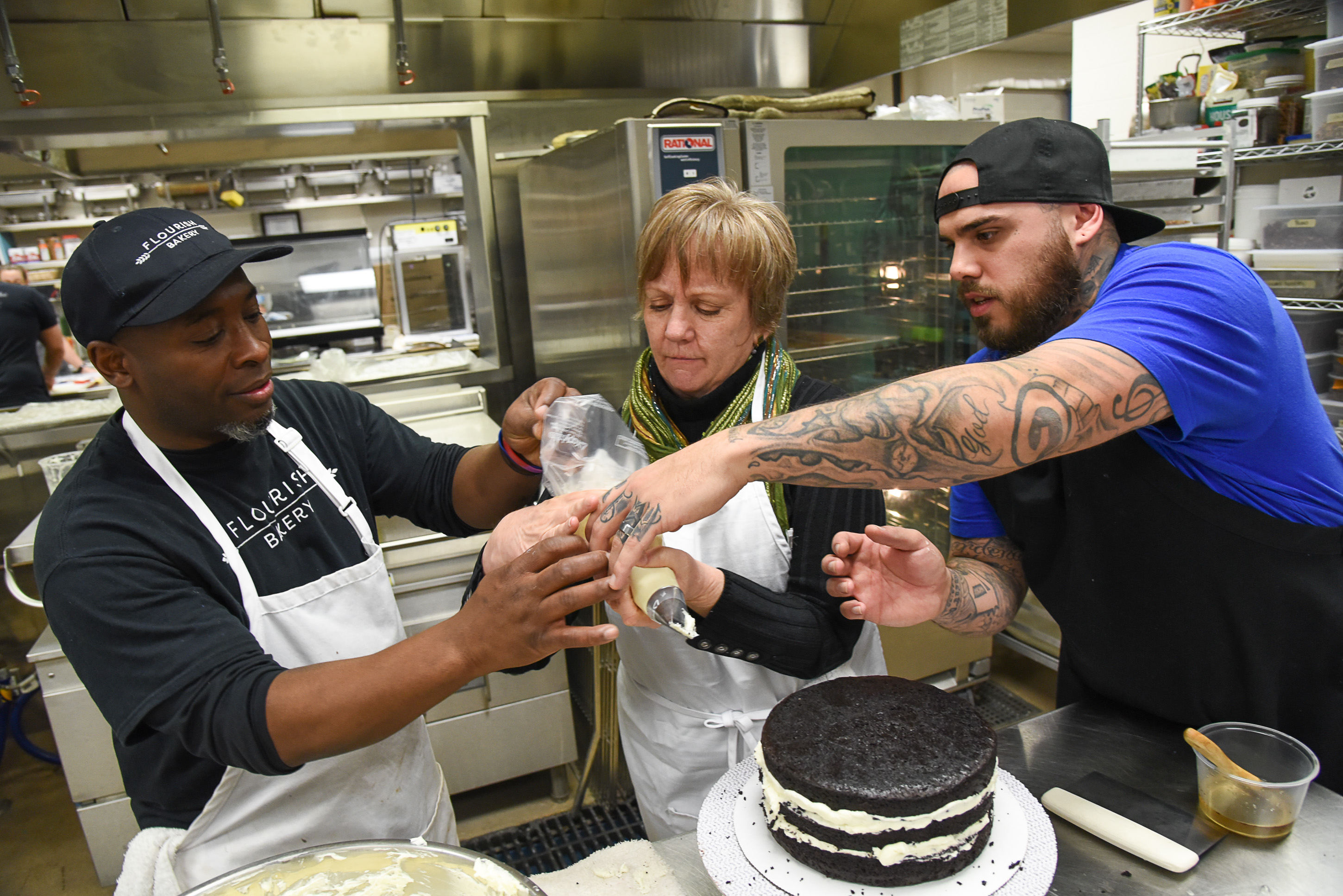 (Francisco Kjolseth | The Salt Lake Tribune) Actress Betsy West gets a little guidance preparing a frosting bag to work on a cake from chef's Frederick Jackson, left, and A.J. Collette as she prepares for an upcoming role of a Southern Baptist bakery owner in North Carolina faced with a request to bake a cake for a gay couple getting married for Salt Lake Acting Company's production of "The Cake." A self admitted baking novice, West, in search of better authenticity in portraying her role received a one-on-one lesson from the chef's at Flourish.