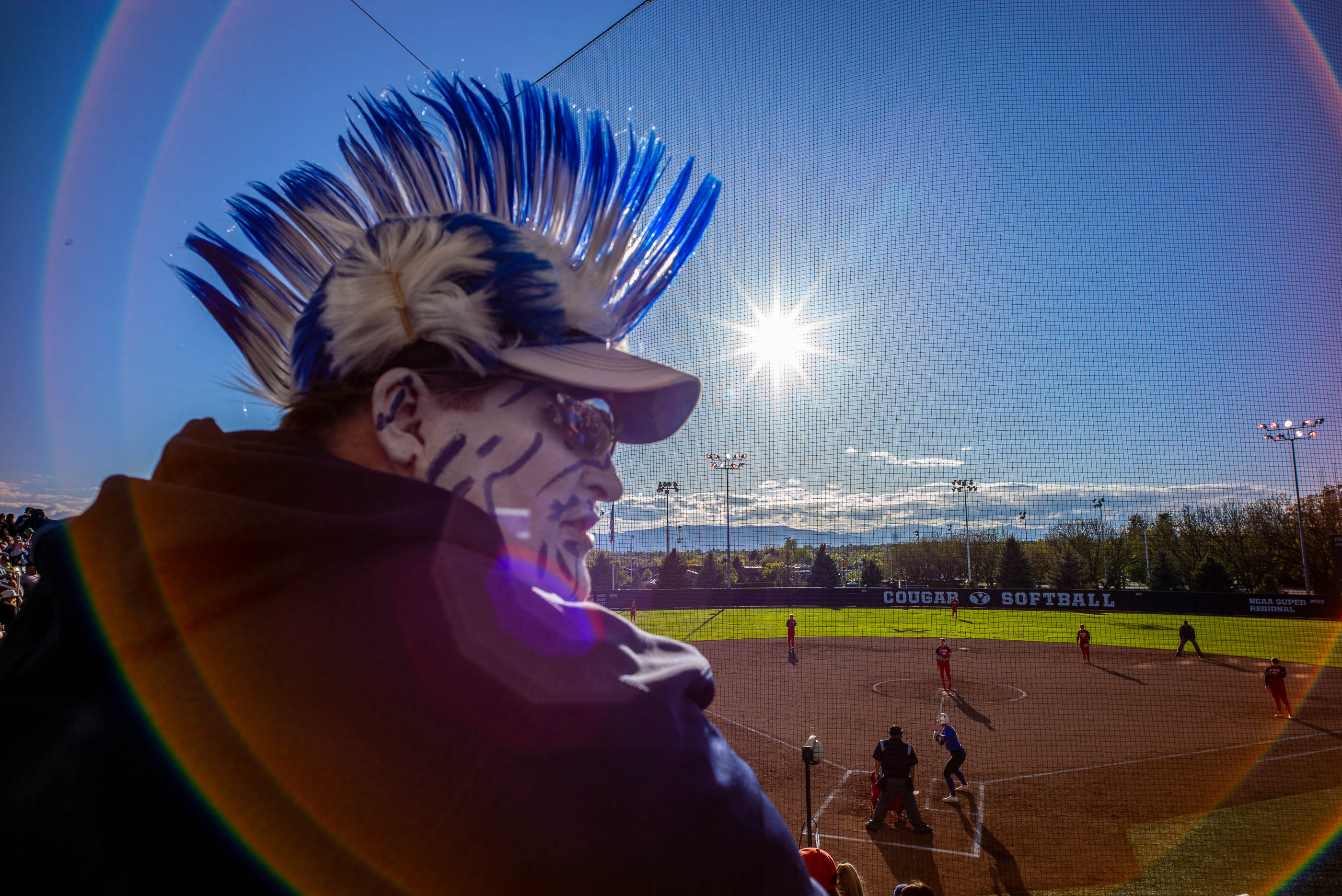 (Trent Nelson | The Salt Lake Tribune) The evening sun flares the lens as BYU fan Troy Beagley watches BYU host the University of Utah, NCAA softball in Provo on Wednesday May 1, 2019.