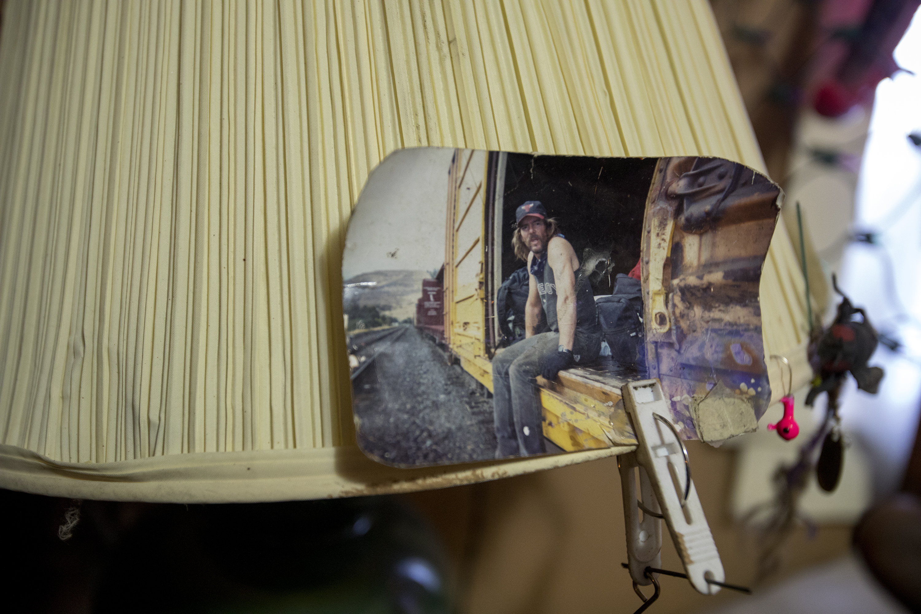 A photo from Doug "Boy Scout" Harding's time hopping trains is clipped to a lamp by the bed at his West Ogden home on Jan. 2, 2018. Harding now describes himself as a "retired hobo." In 2016 he moved into housing with assistance from Weber Housing Authority. "I don't want to die alone on the railroad tracks with a 40-ounce for a friend," said Harding after moving into his apartment. (Benjamin Zack/Standard-Examiner via AP)
