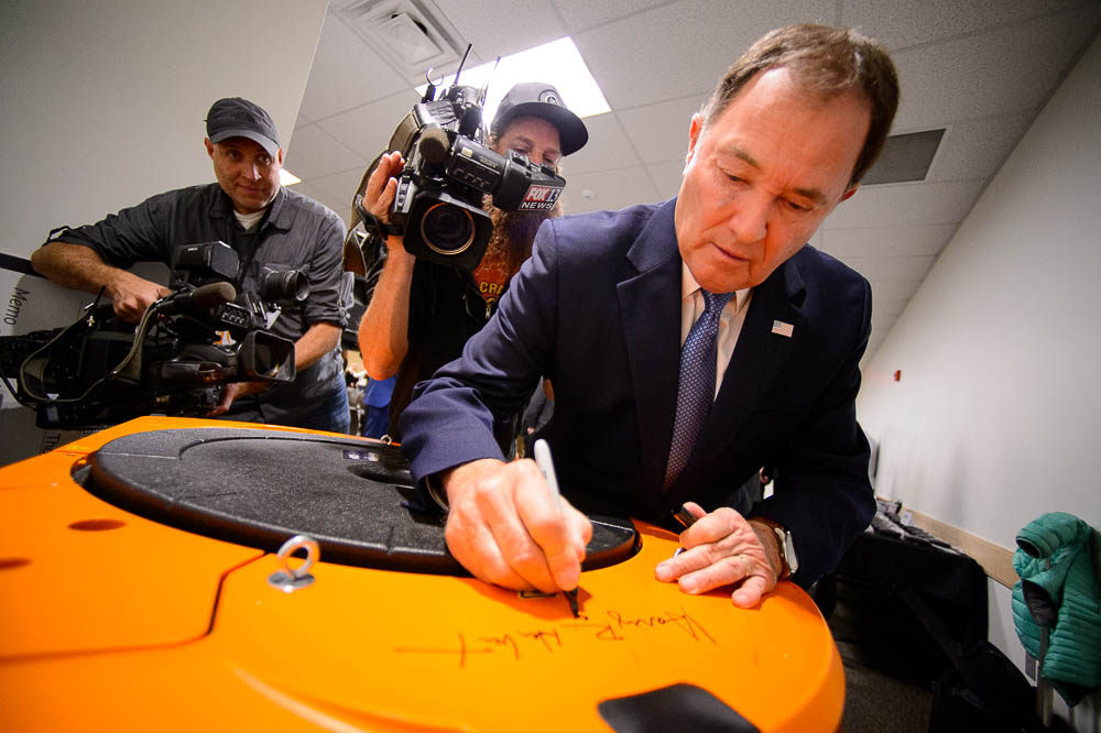 (Trent Nelson | The Salt Lake Tribune) Utah Governor Gary Herbert puts his signature on a robot at Amazon's fulfillment center in Salt Lake City on Wednesday April 17, 2019.