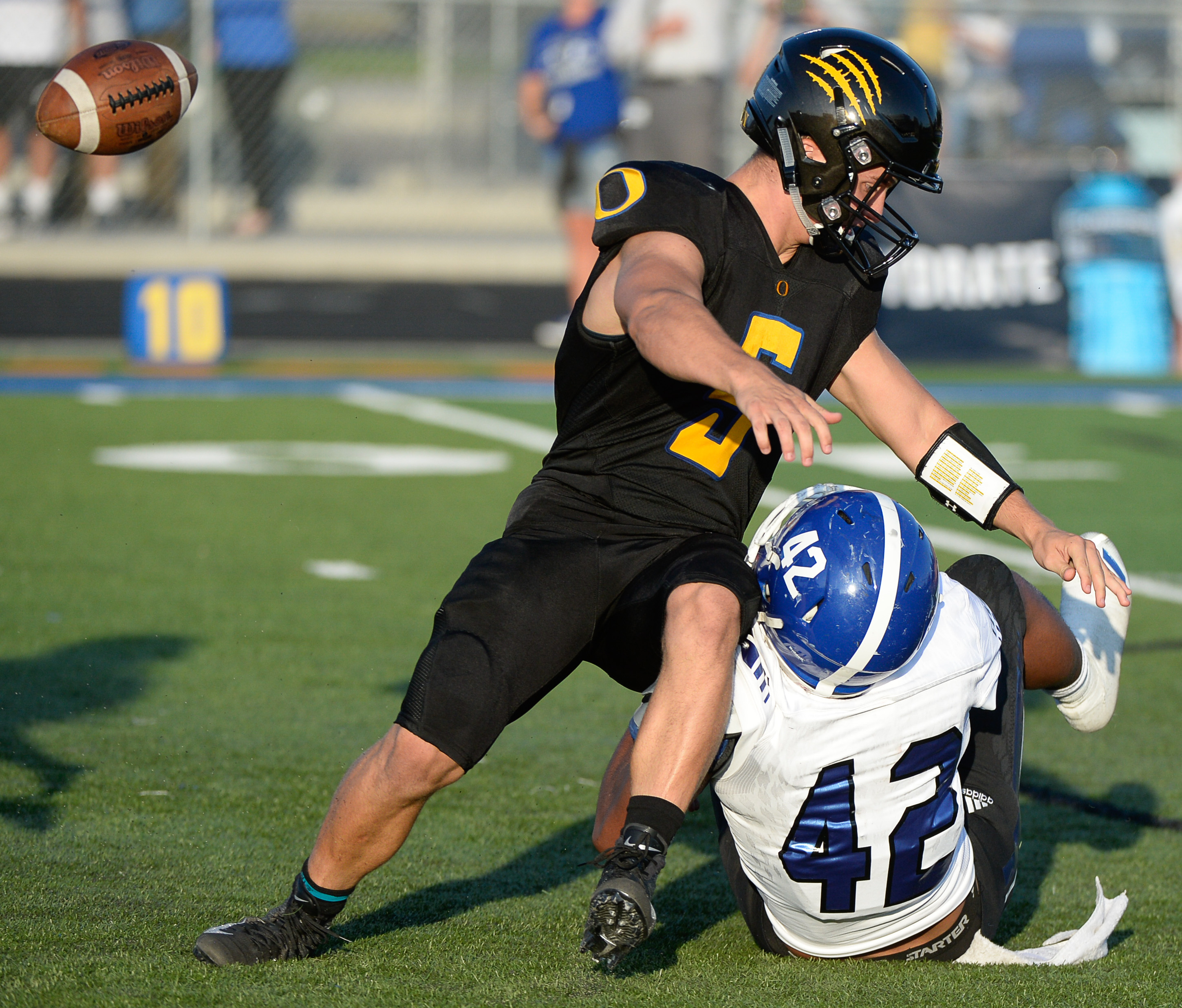 (Francisco Kjolseth | The Salt Lake Tribune) Orem's quarterback Cooper Legas is taken down by Bingham's Sione Fotu in the first half of the game Thursday, Aug. 16, 2018 in Orem.