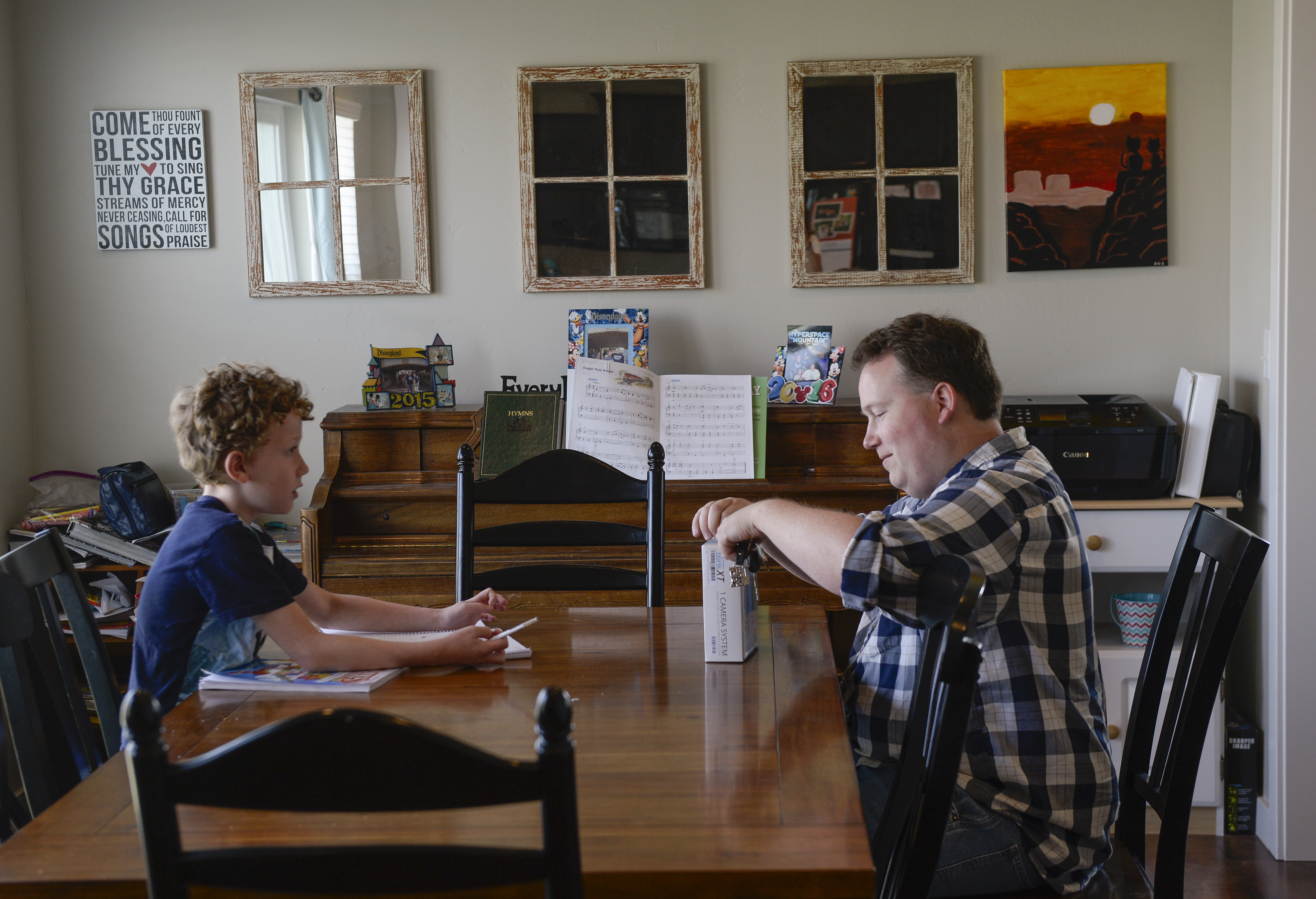 (Leah Hogsten | The Salt Lake Tribune) Toby Irvin, 10, questions his father, Nate Irvin, who chuckles as Toby pens a "Dear POTUS" letter as the two sit at the dining room table.