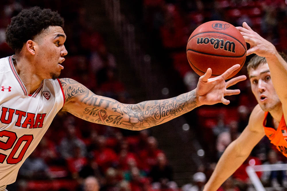 (Trent Nelson | The Salt Lake Tribune) Utah Utes forward Timmy Allen (20) and Oregon State Beavers forward Tres Tinkle (3) reach for a loose ball as Utah hosts Oregon State, NCAA basketball in Salt Lake City on Saturday Feb. 2, 2019.