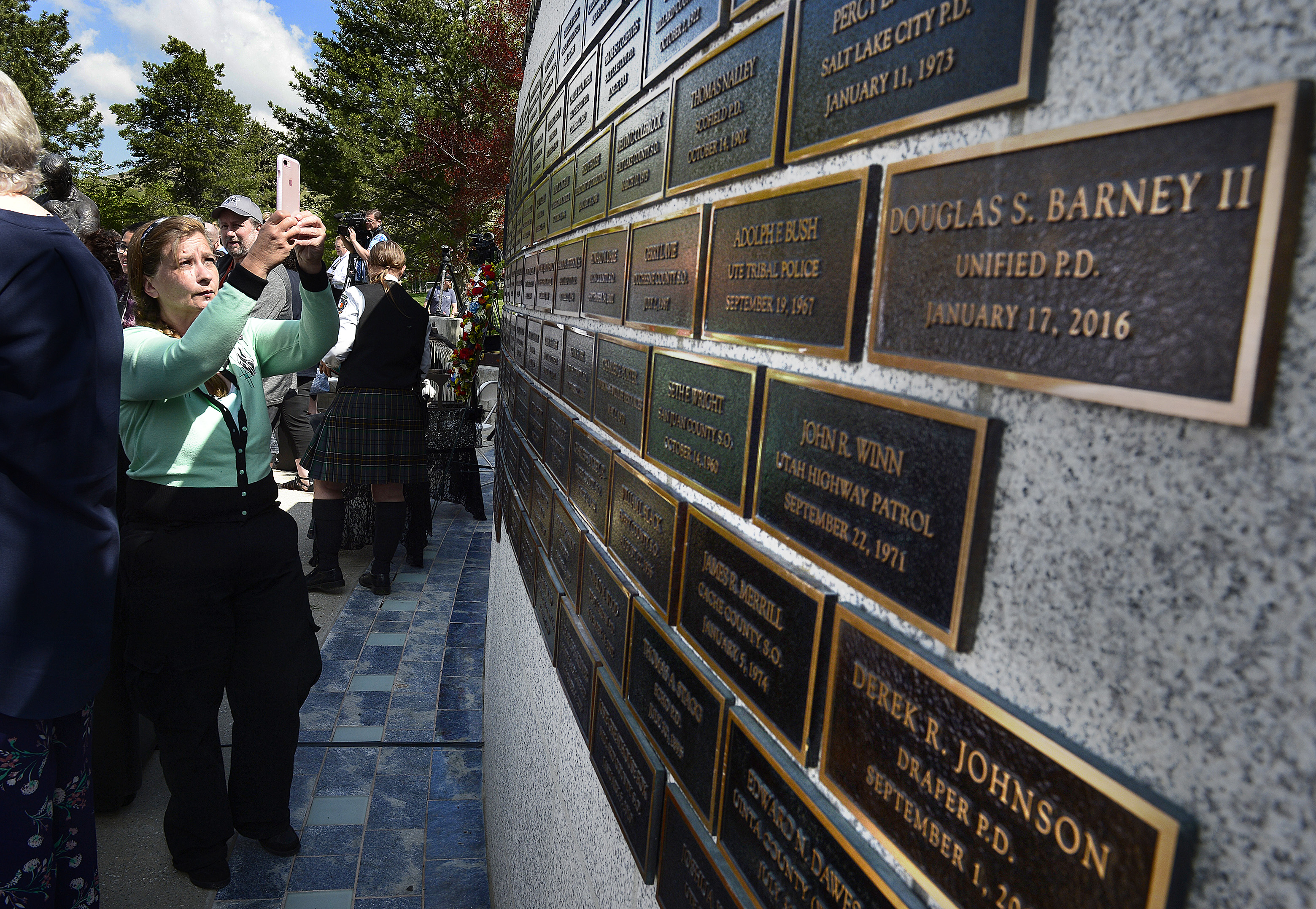 (Scott Sommerdorf | The Salt Lake Tribune) People make photos of the names on the memorial wall at the end of the Utah Law Enforcement Memorial honoring the 142 police officers killed in the line of duty during the state's history, Thursday, May 3, 2018. No Utah law enforcement officer died in the line of duty last year.