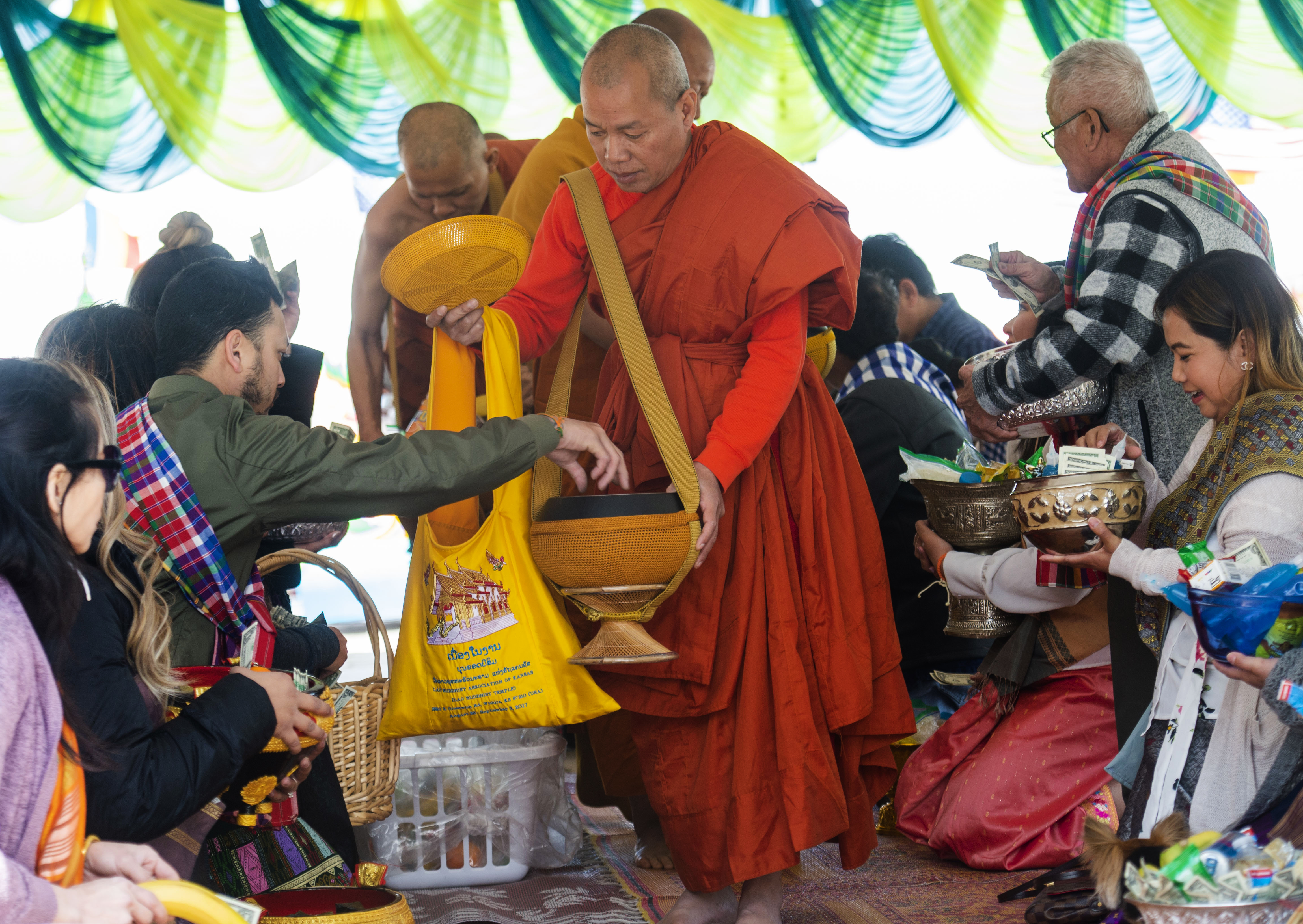 (Rick Egan | The Salt Lake Tribune) Participants make donations to the monks, at the Wat Lao Salt Lake Buddharam Utah, New Year Celebration, in West Valley City, Sunday, April 28, 2019. 