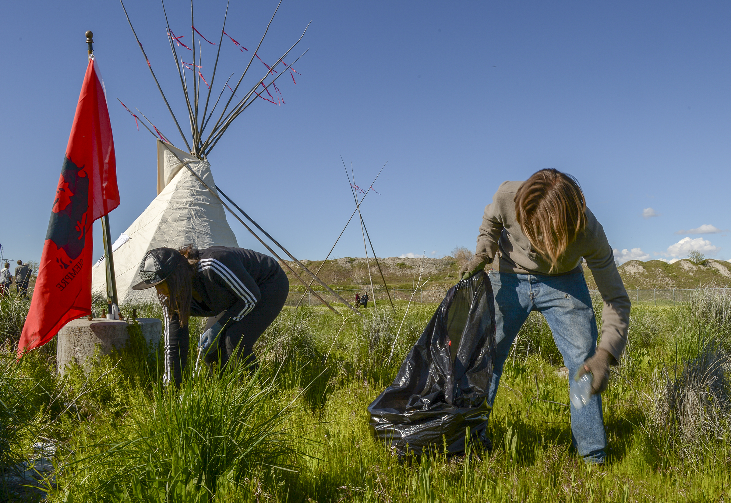 Leah Hogsten | The Salt Lake Tribune l-r Mandy Rough and Darin Mann pick up trash at a dump site on 7200 West and I-80. The "Stop the Polluting Port" community coalition staged a May Day celebration, calling for respect and awareness of the water, earth and air regarding the 20,000 acres west of Salt Lake City where the inland port industrial site has been proposed.