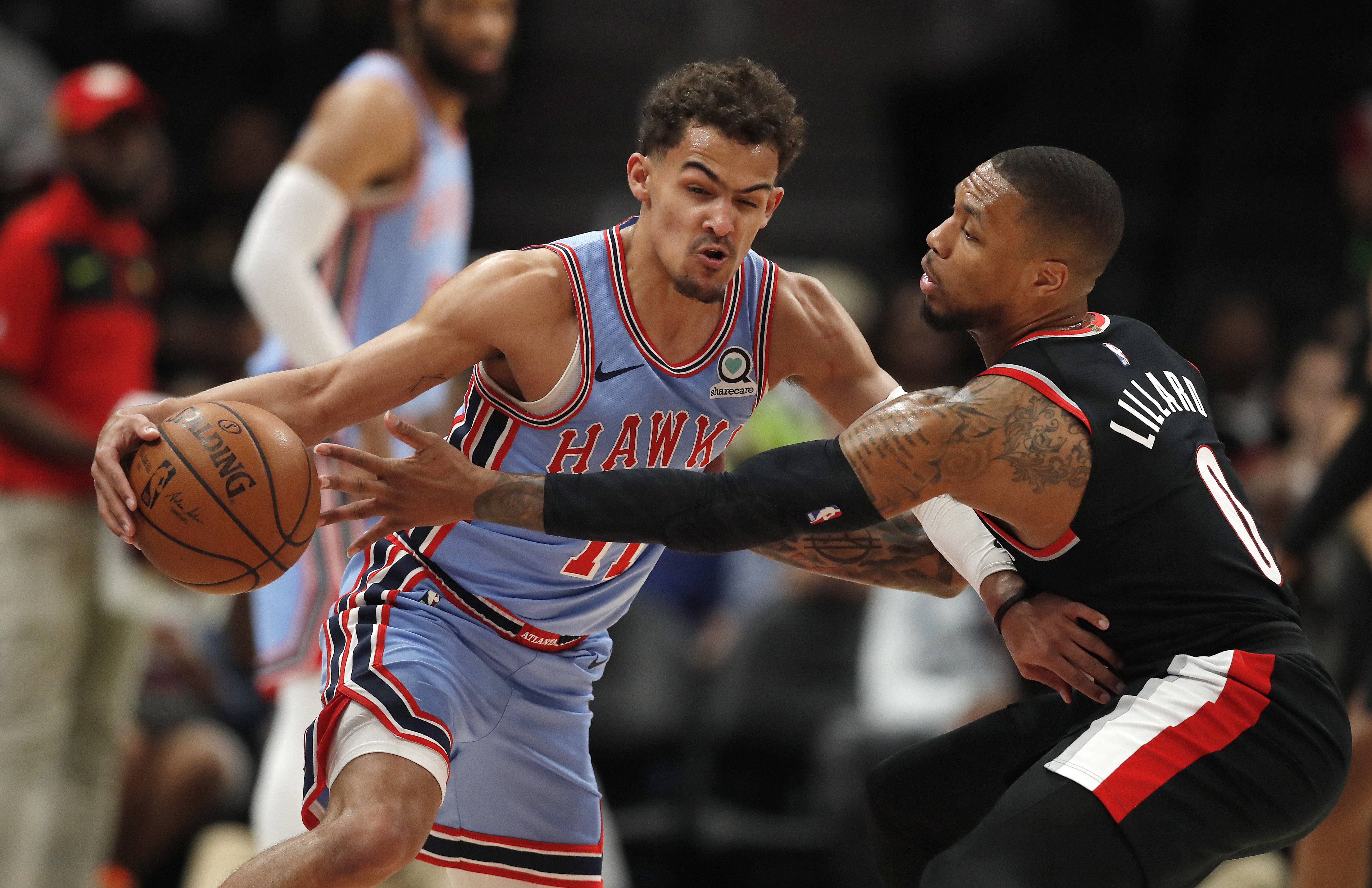 Atlanta Hawks guard Trae Young (11) works against Portland Trail Blazers guard Damian Lillard (0) in the first half of an NBA basketball game Friday, March 29, 2019, in Atlanta. (AP Photo/John Bazemore)