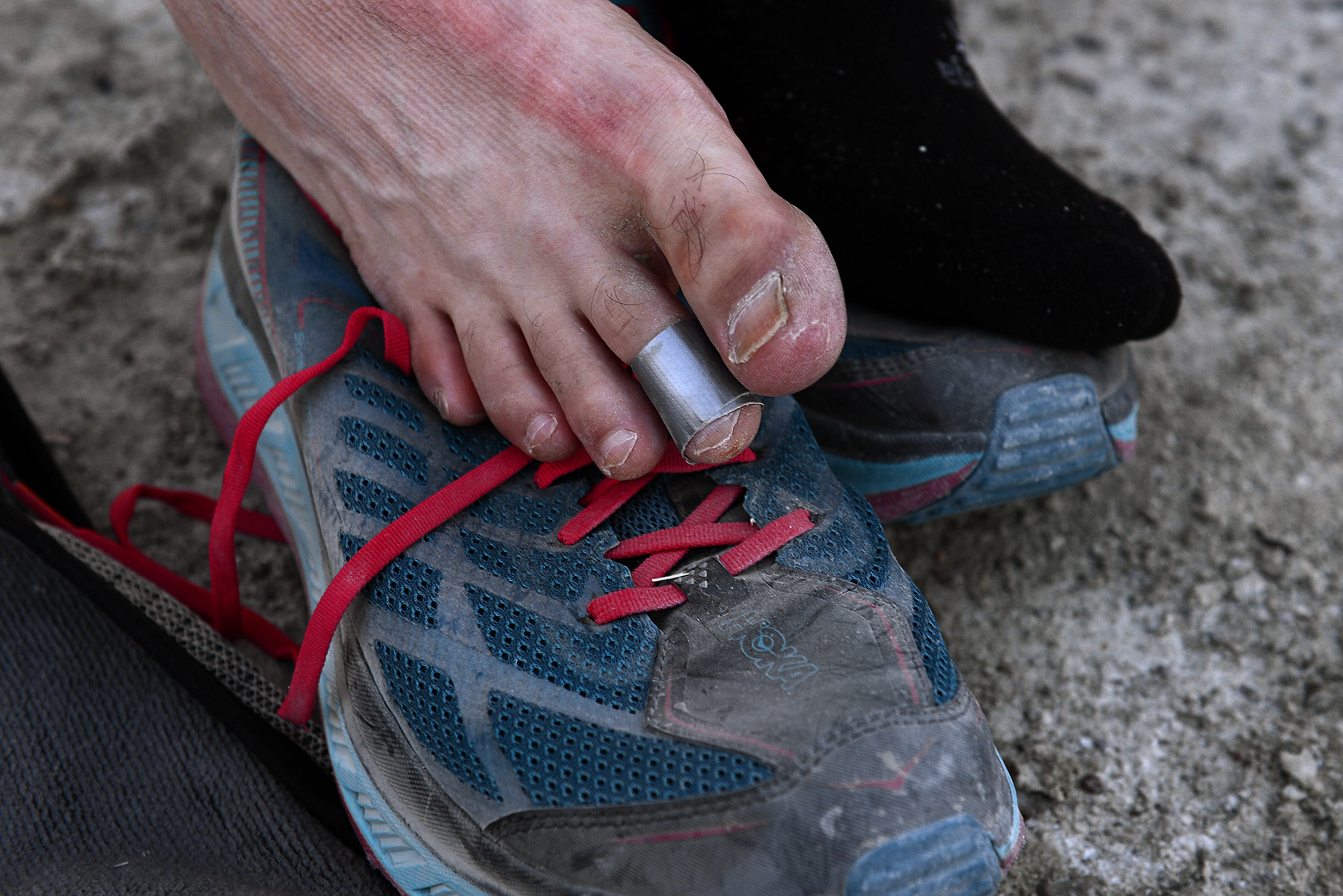 (Scott Sommerdorf | The Salt Lake Tribune) Alex Doolan changes his socks at the last checkpoint at the Salt Flats 100 Endurance Run, Saturday, May 5, 2018. His toes were bandaged with duct tape. 
