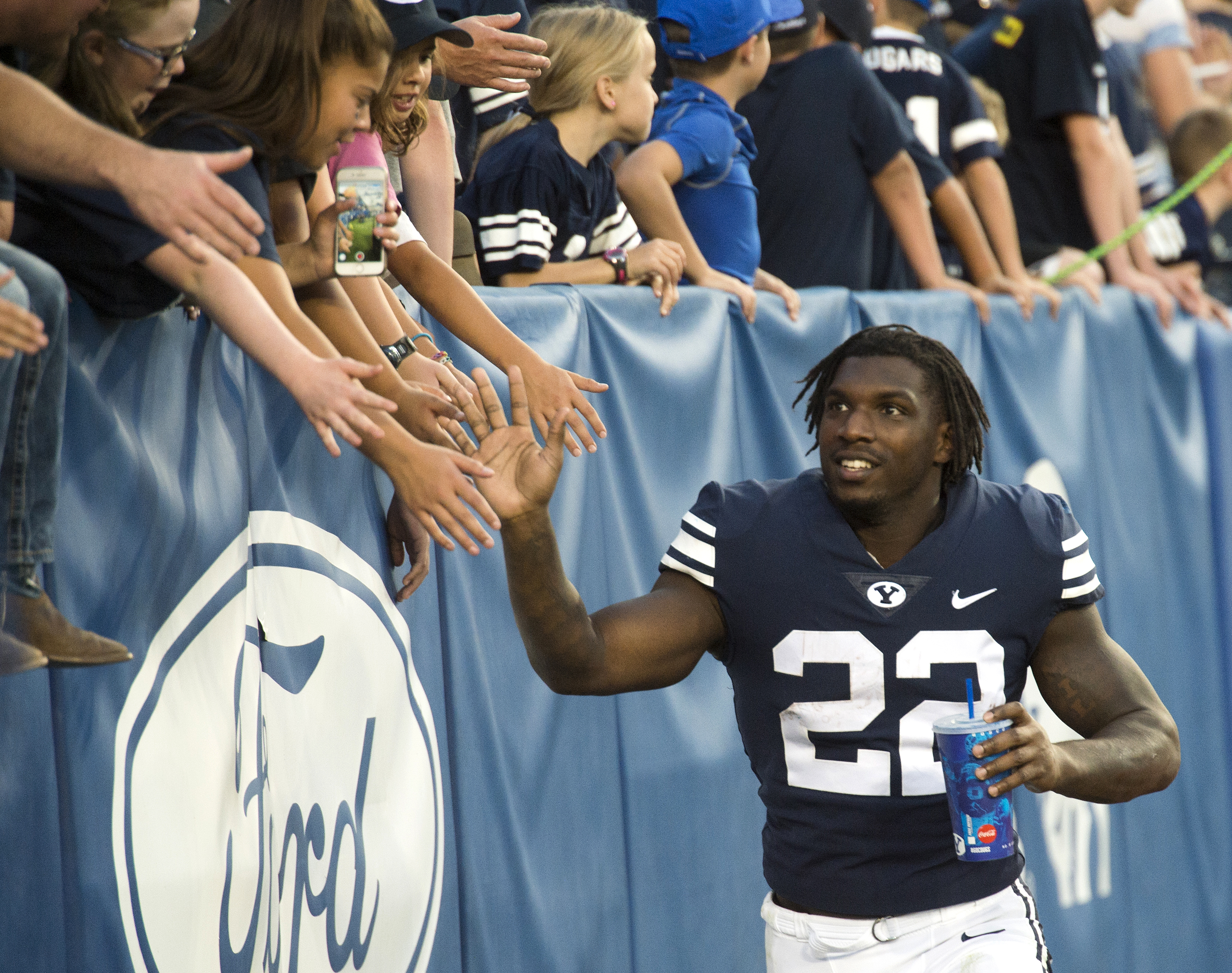 (Rick Egan | The Salt Lake Tribune) Brigham Young Cougars running back Squally Canada (22) high-fives the crowd after the Brigham Young Cougars defeated the McNeese State Cowboys 30-3, at Lavell Edwards Stadium, Saturday, Sept. 22, 2018. 