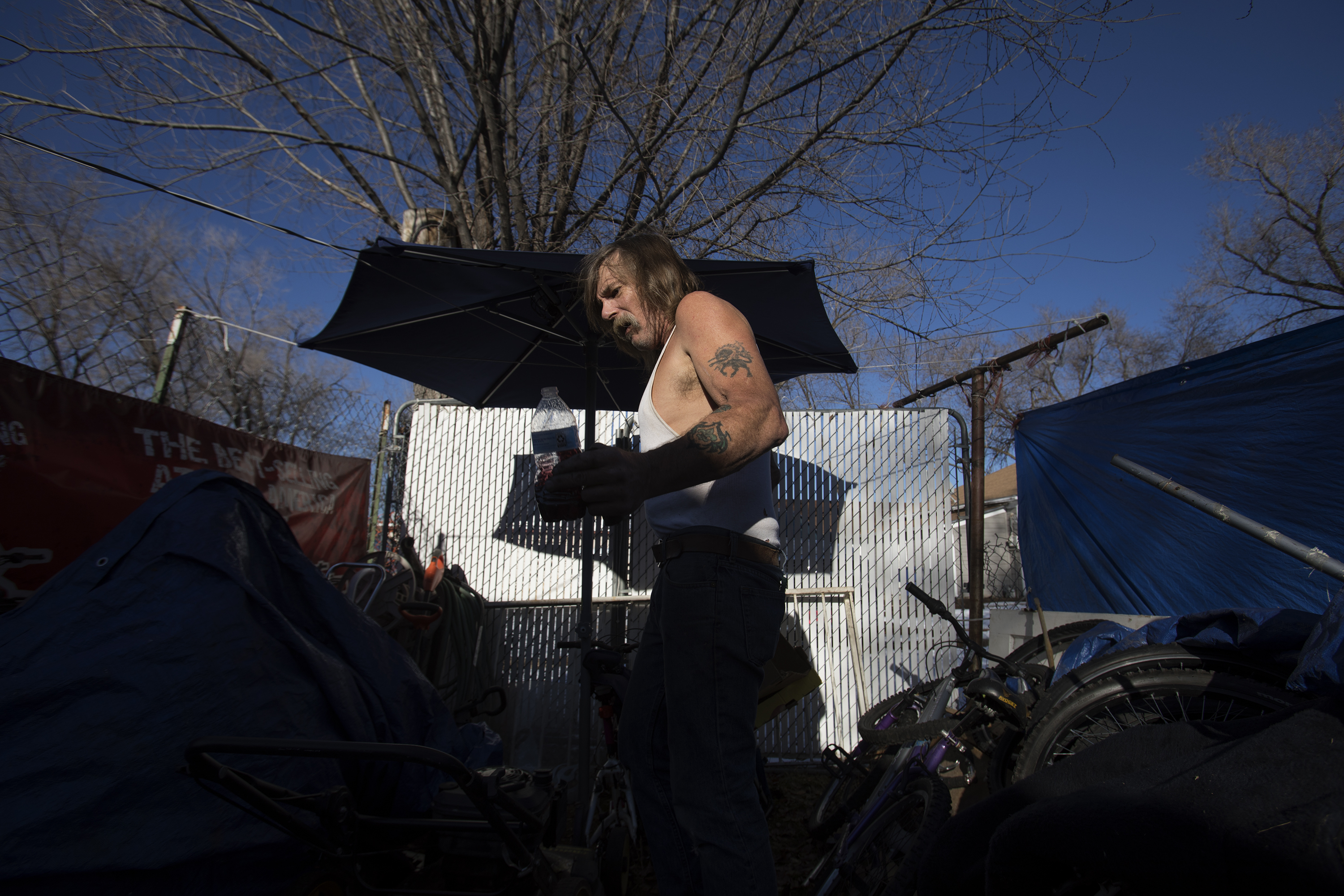Doug "Boy Scout" Harding sorts through the miscellaneous bikes, furniture and tools he keeps behind his West Ogden home on Jan. 2, 2018. Harding occasionally works odd jobs, but he also regularly dumpster dives for recyclables, scrap metal and items that can be resold. (Benjamin Zack/Standard-Examiner via AP)