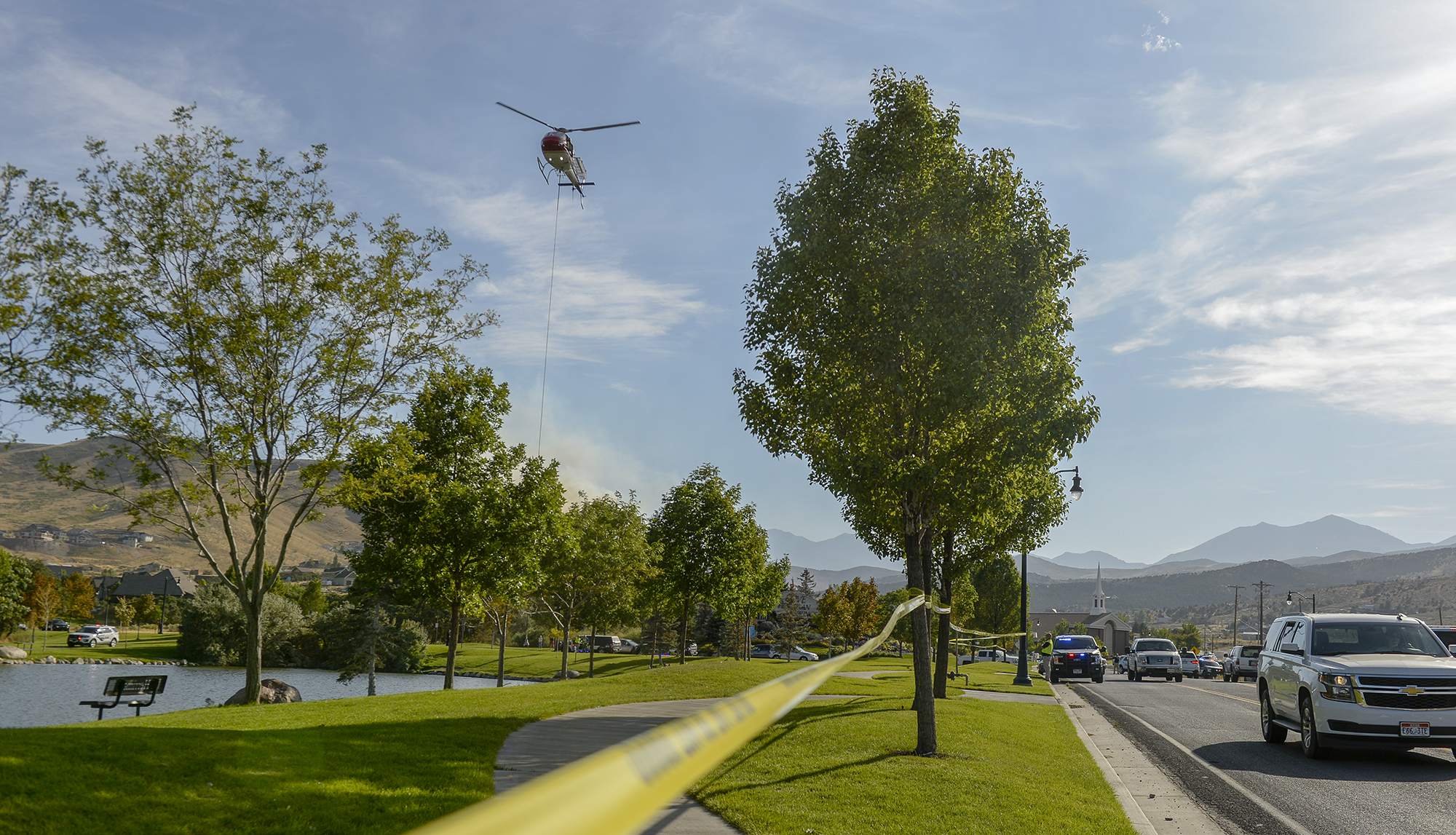 Leah Hogsten | The Salt Lake Tribune A firefighting helicopter refills with water near Herriman Cove pond. A 50-acre wildfire in Rose Canyon was threatened about a half-dozen homes Wednesday, Sept. 12, 2018. A spokesman for Unified Fire said the blaze has already burned a few structures, including outhouses and sheds. Firefighters have evacuated around 20 to 30 homes in two neighborhoods near 15555 S. Rose Canyon Road in Herriman. 