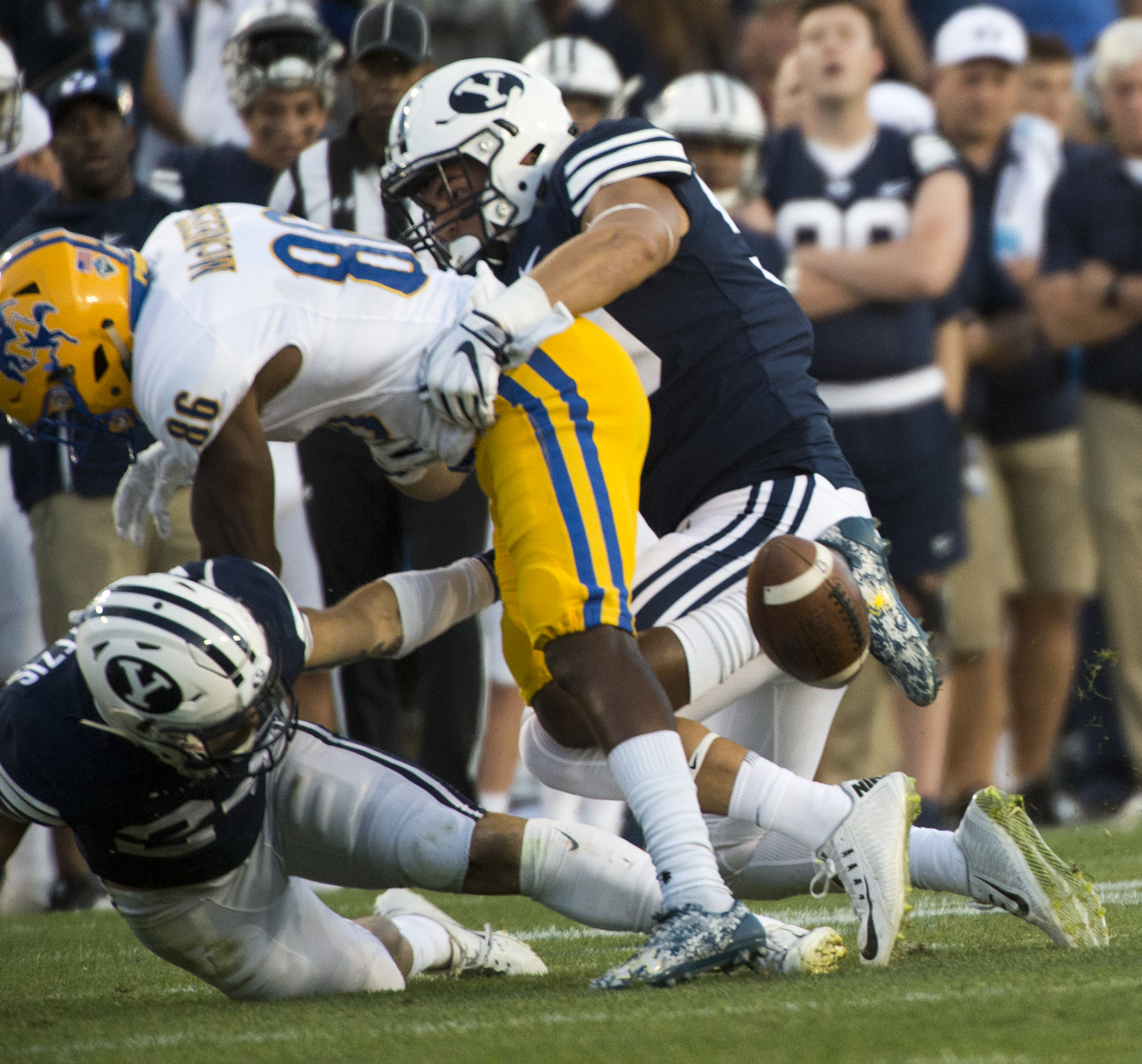 (Rick Egan | The Salt Lake Tribune) Brigham Young Cougars defensive back Austin Kafentzis (24) and linebacker Nate Sampson (50), force a fumble as they hit McNeese State Cowboys wide receiver Rodnell Cruell (86), in football action Brigham Young Cougars vs McNeese State Cowboys at Lavell Edwards Stadium, Saturday, Sept. 22, 2018. 