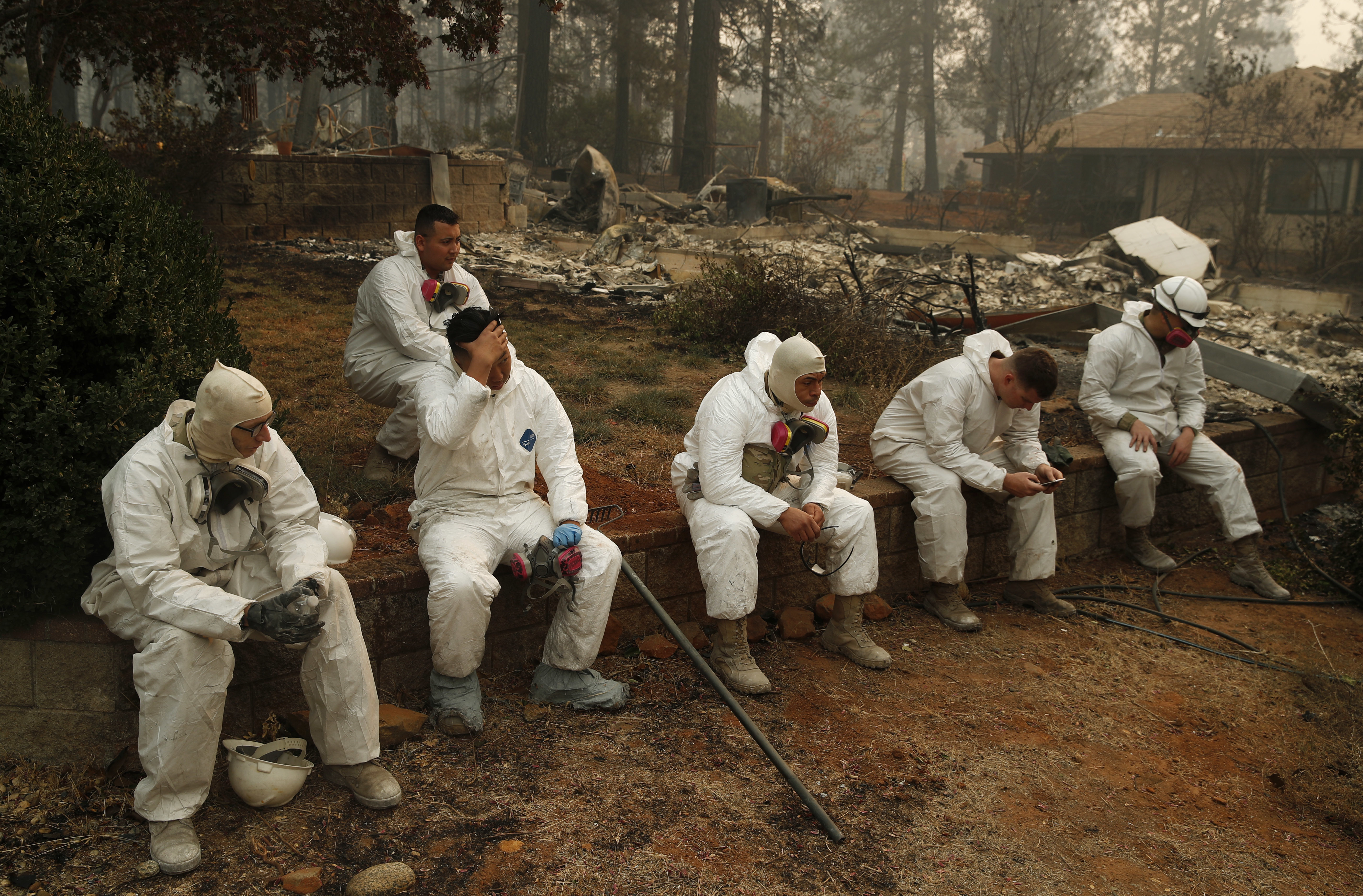 Members of the California Army National Guard take a break at they search burned homes for human remains at the Camp Fire, Thursday, Nov. 15, 2018, in Paradise, Calif. (AP Photo/John Locher)