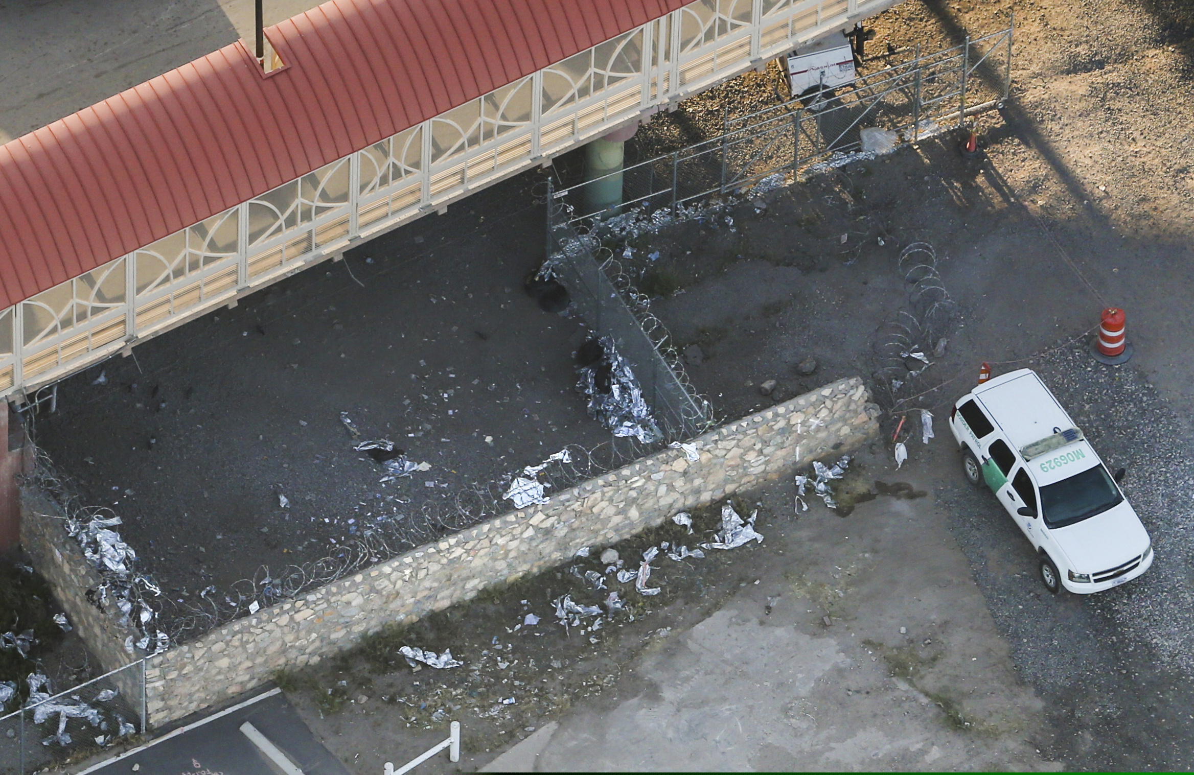 Shreds of Mylar blankets and a Border Patrol vehicle are seen under the Paso del Norte Port of Entry bridge in El Paso, Texas, on Sunday, March 31, 2019. Migrants, including young children and babies, seeking asylum were being kept in a U.S. Border Patrol temporary holding area under the bridge. Some migrants were held there for as many as four days and were forced to sleep outside on gravel, provided only thin Mylar blankets for warmth. (Ryan Michalesko/The Dallas Morning News via AP)
