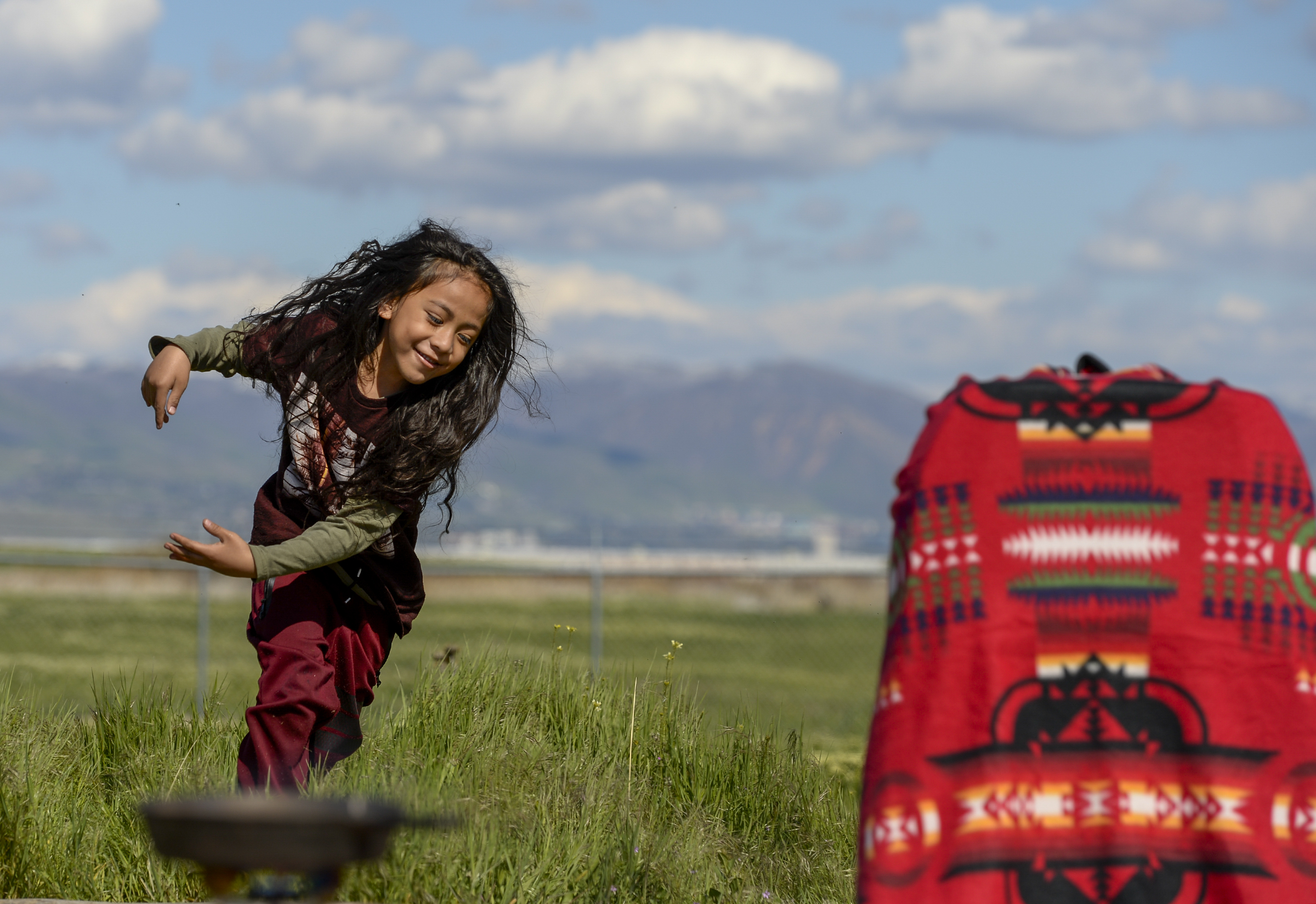 Leah Hogsten | The Salt Lake Tribune Tangata 'Olakepa Tavi plays in the field near the ceremony. The "Stop the Polluting Port" community coalition staged a May Day celebration, calling for respect and awareness of the water, earth and air regarding the 20,000 acres west of Salt Lake City where the inland port industrial site has been proposed.
