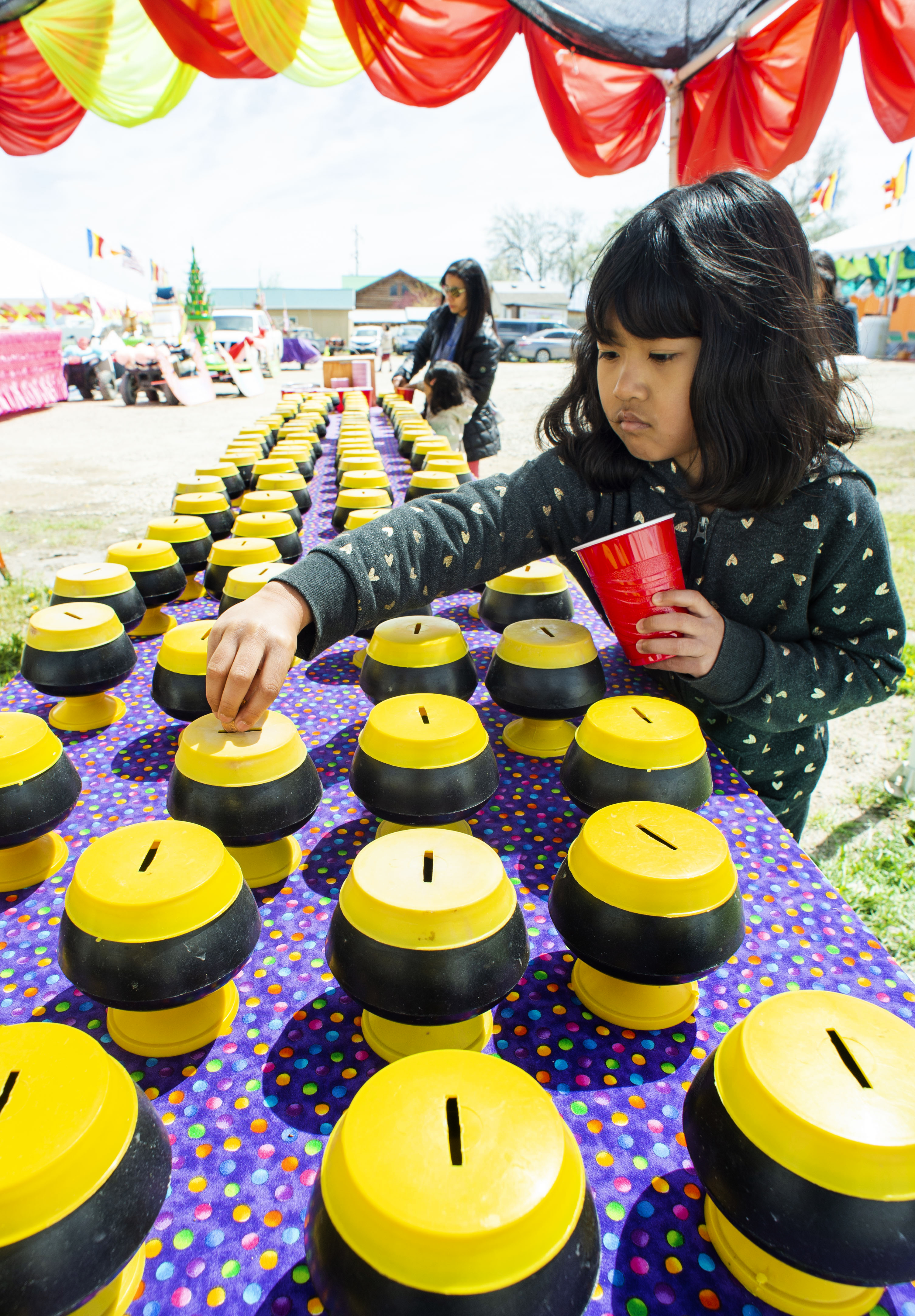 (Rick Egan | The Salt Lake Tribune) Jawmarana Trai 8, puts money in the bank for the monks, during the Wat Lao Salt Lake Buddharam Utah, New Year Celebration, in West Valley City, Sunday, April 28, 2019. 
