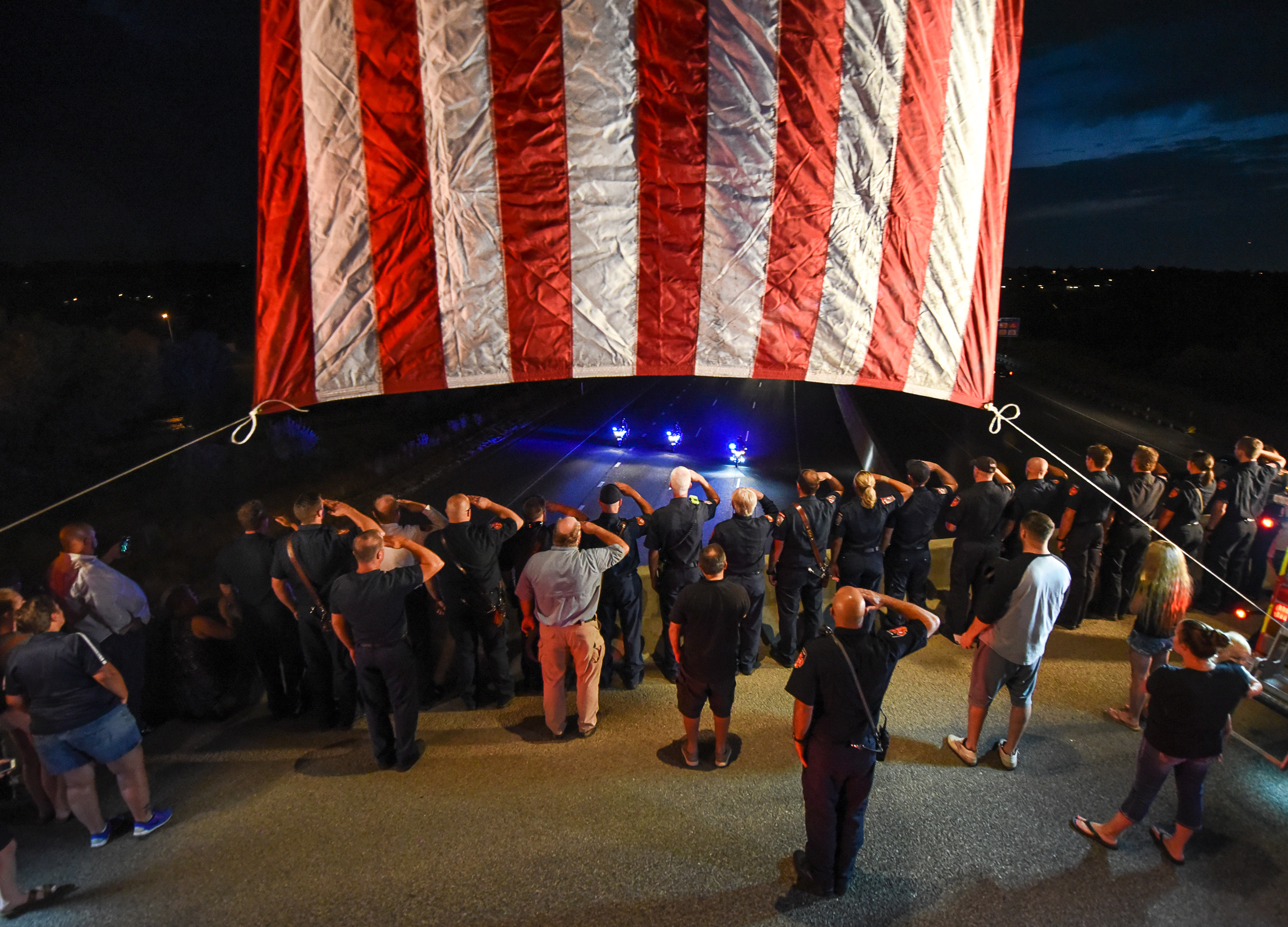 (Francisco Kjolseth | The Salt Lake Tribune) The body of Utah firefighter Matt Burchett, 42, who died fighting a wildfire in California is honored by a firefighter detail along Murray Parkway as his body is returned home, traveling along I-215 after being flown in to the Utah Air National Guard in Salt Lake City on Wed. Aug. 15, 2018. The remains of the Draper battalion chief were transported to Jenkins-Soffe Mortuary in South Jordan.